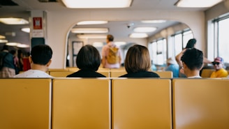 People sit on a ferry, observing the passengers.