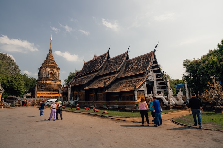 An ornate temple with people milling about.