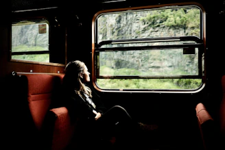 Woman looks out a train window at the scenery.