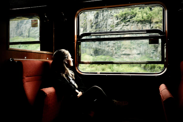 Woman looks out a train window at the scenery.