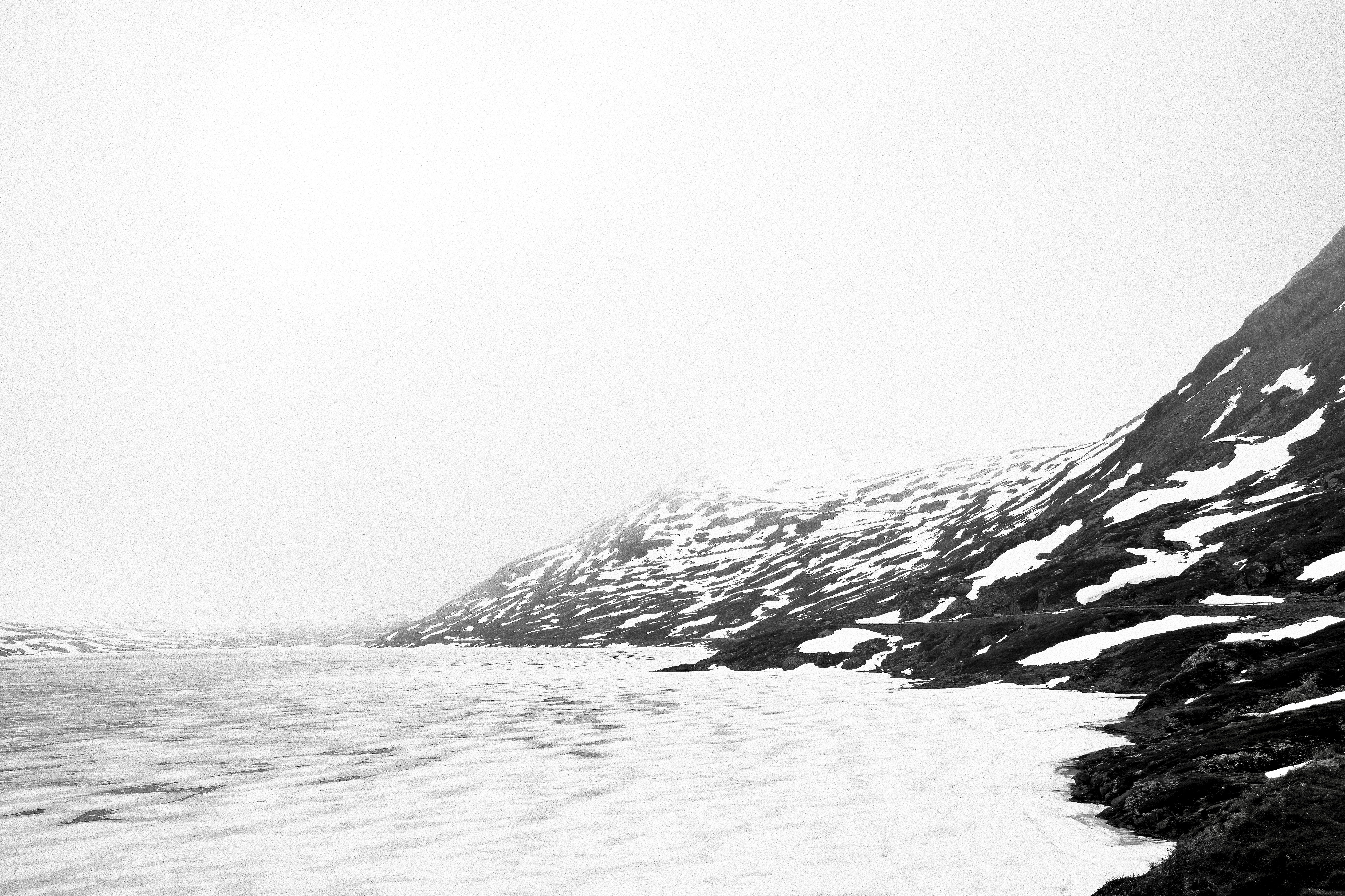 雪に覆われた山脈は凍った湖に隣接しています。