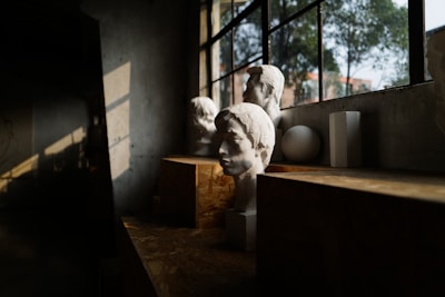 Sculptures sit in a sunlit workshop window.