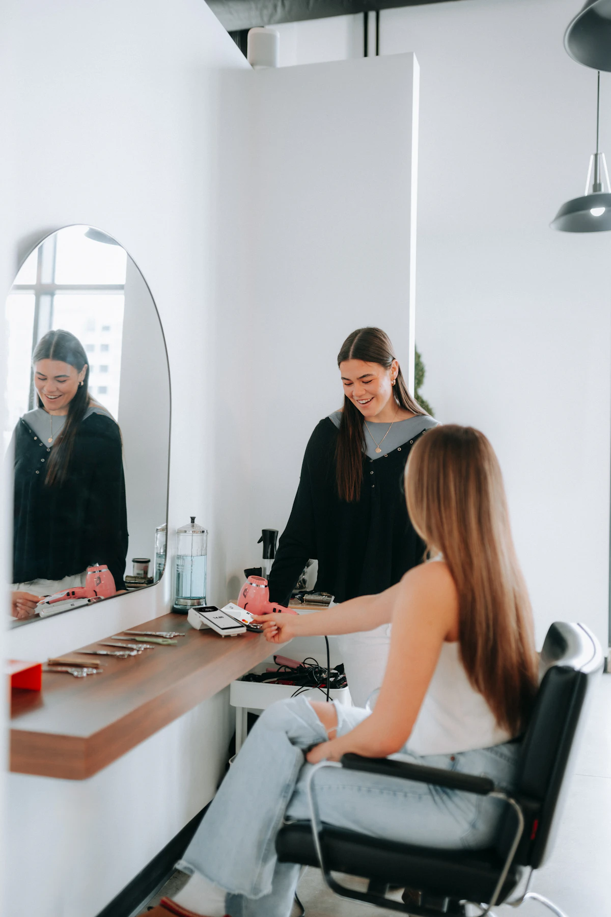 A hairstylist consulting with a client in a salon chair