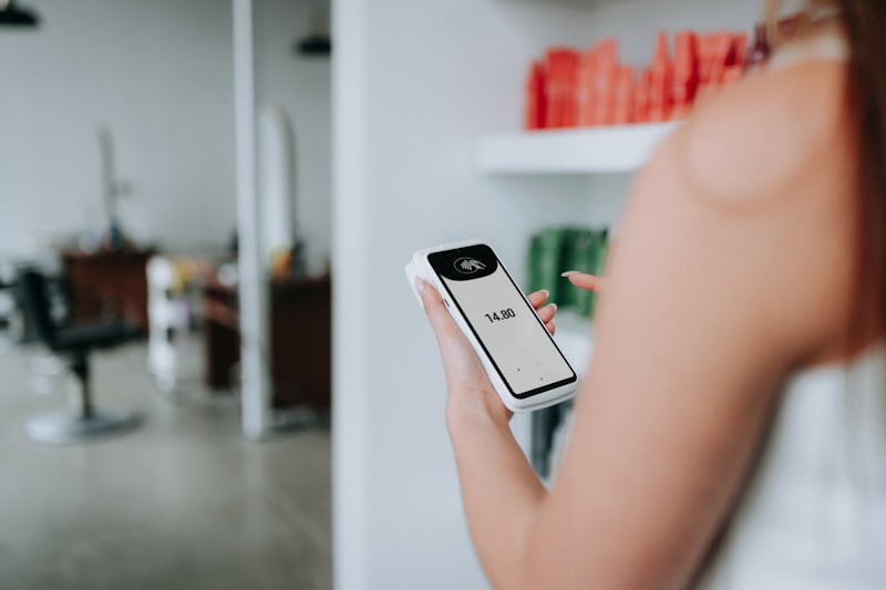 Someone holding a payment terminal at a salon to collect a deposit