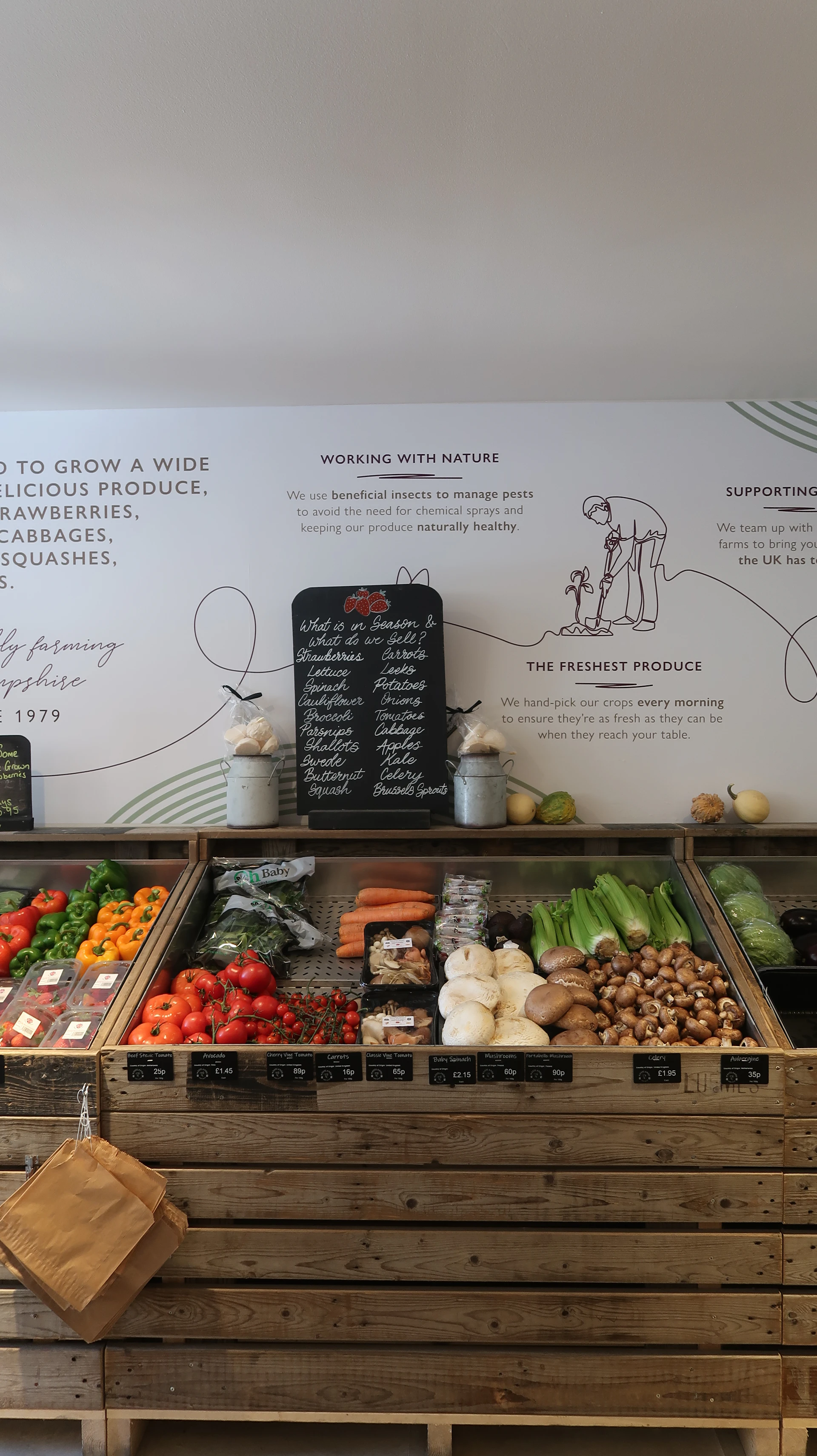 Fresh vegetables displayed in wooden crates at a farm shop