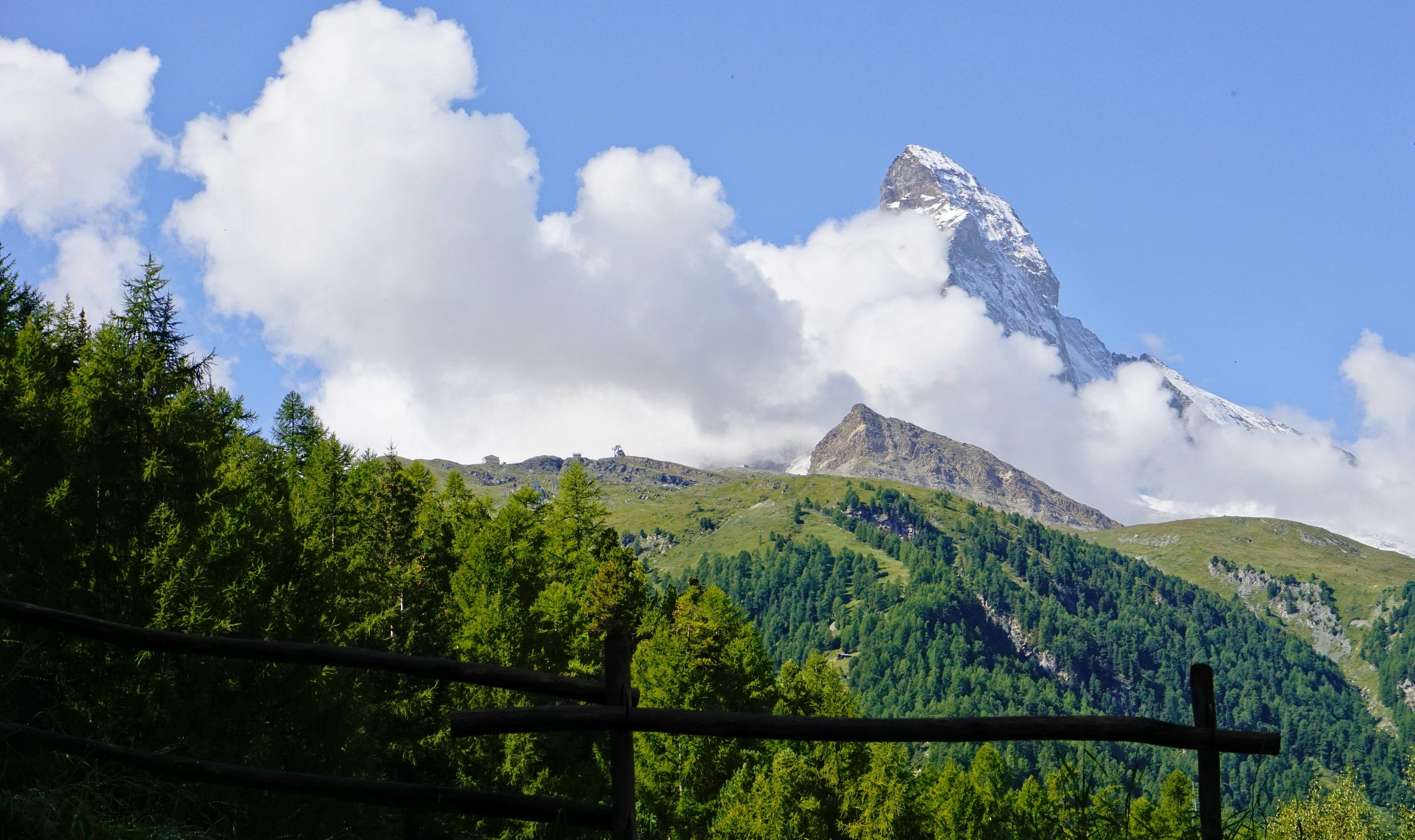 Les montagnes et les arbres sont sous un ciel nuageux.