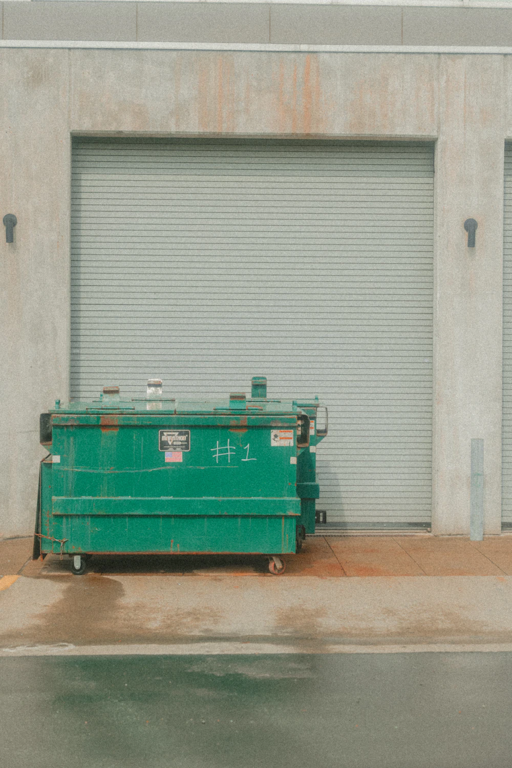 Real commercial dumpsters positioned near a loading dock