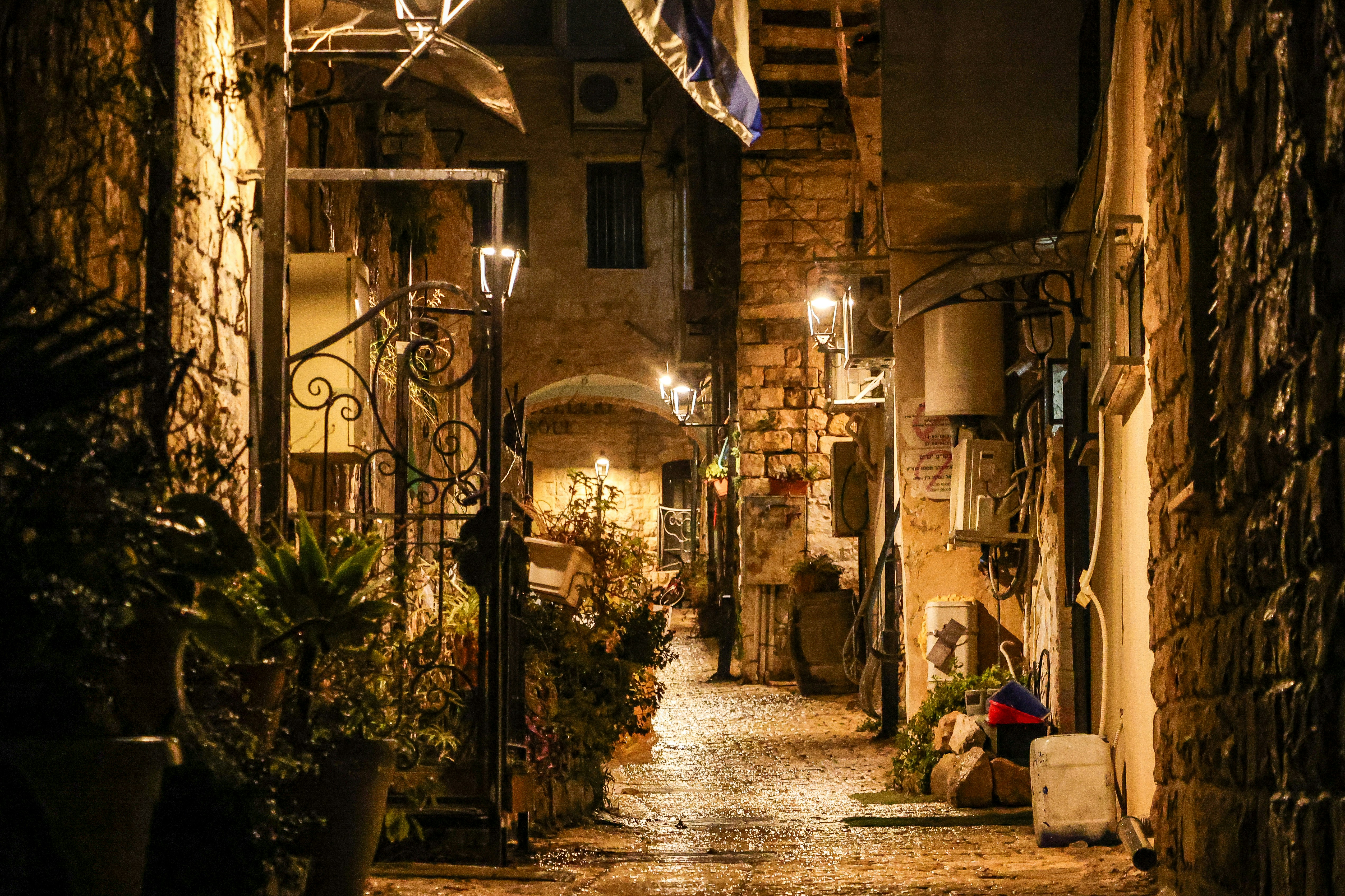 A narrow, illuminated alleyway at night.