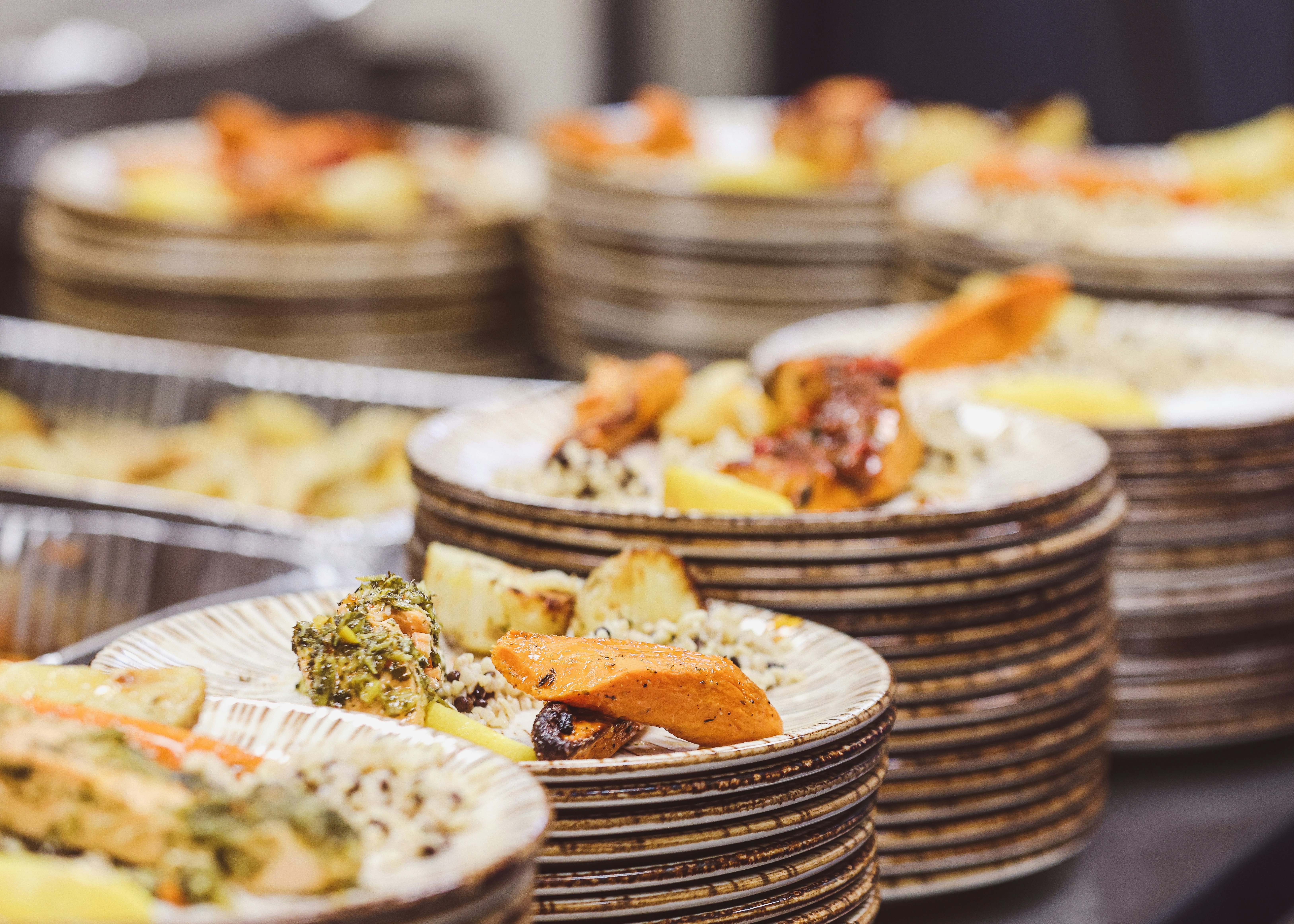 Plates of food are stacked and ready to be served.