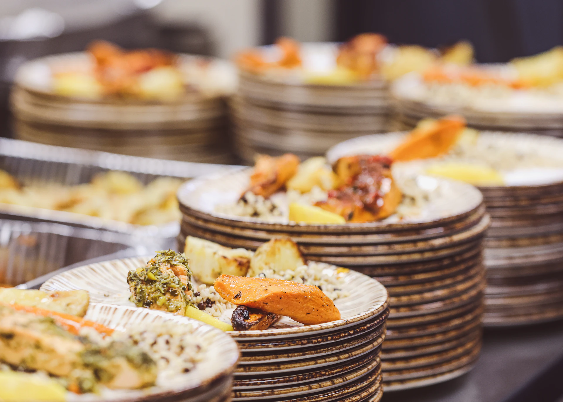 Plates of food are stacked and ready to be served.