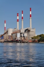 Power plant with chimneys against a blue sky.
