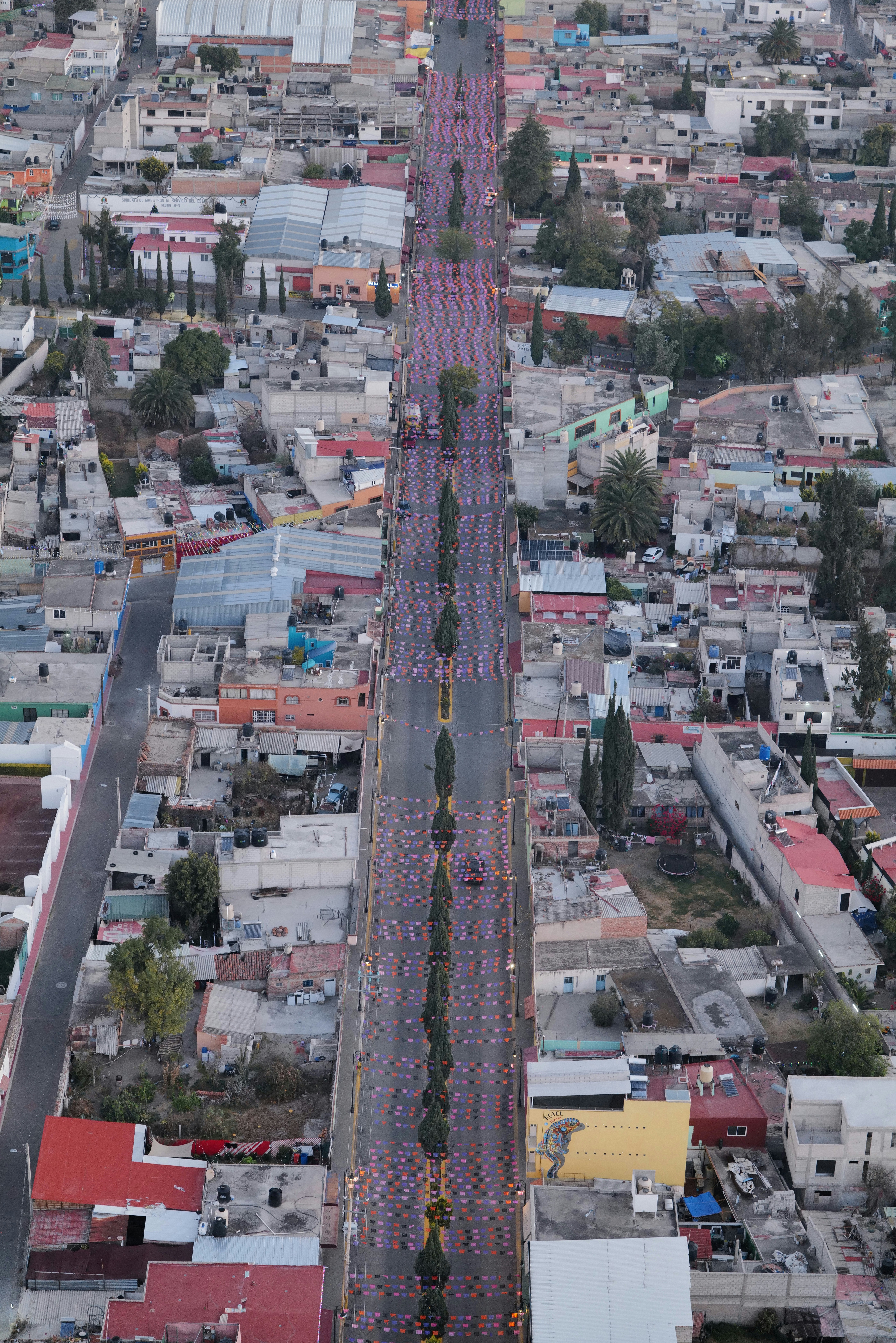 People march down a long street in a city.