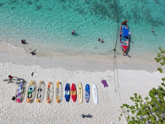 Beach with boats and kayaks on the water.