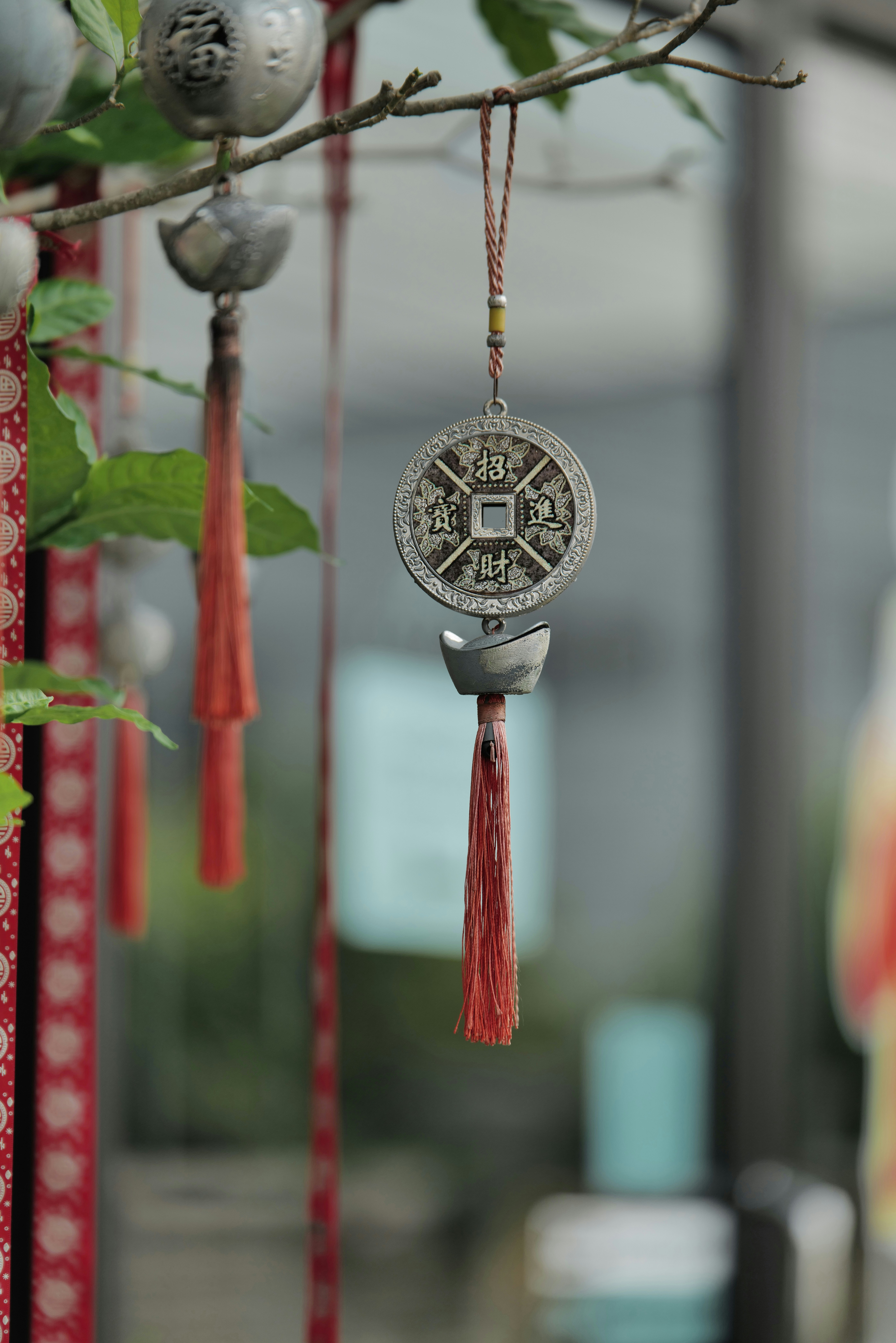 Coin ornaments hang from branches, decorated in red.