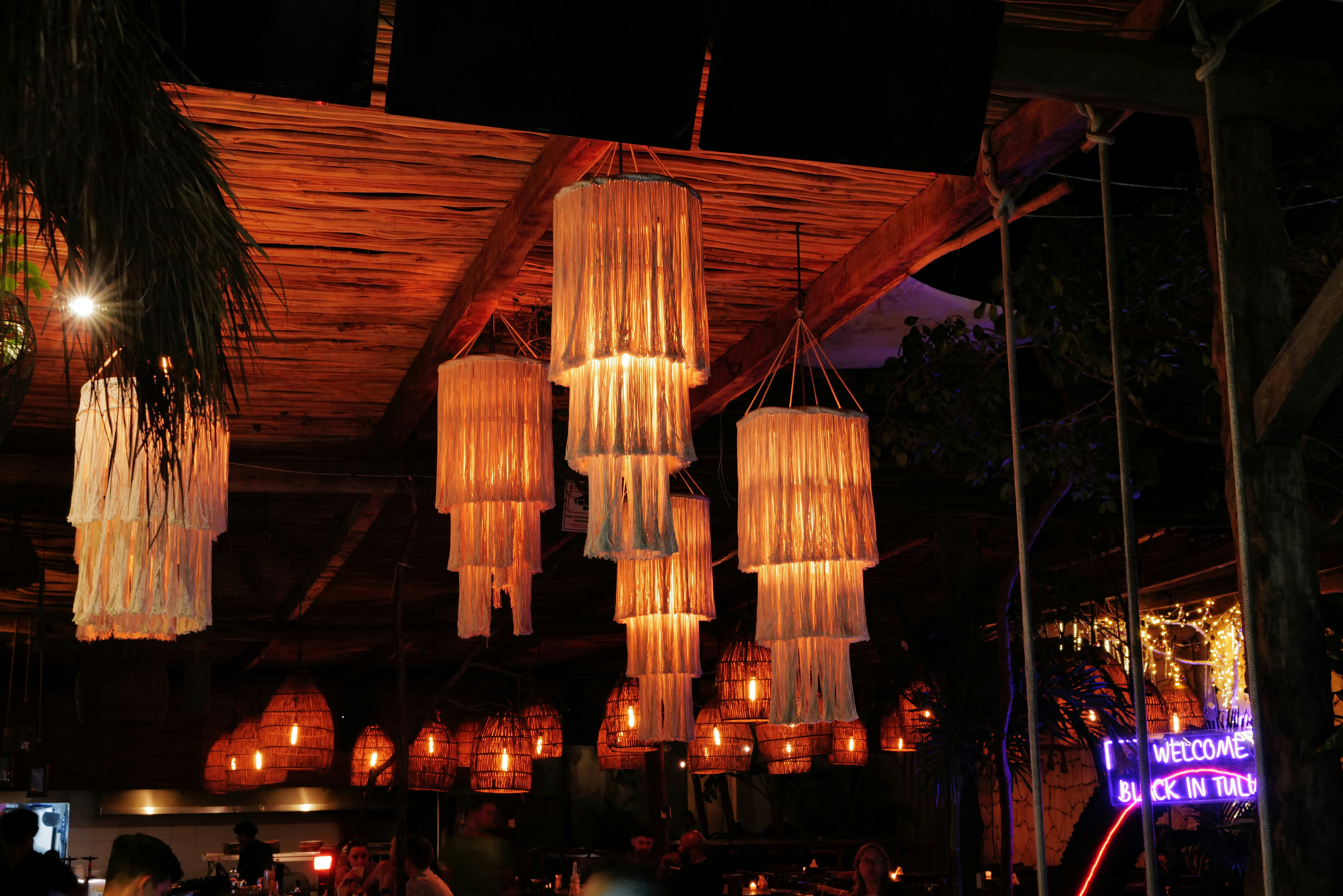 Warm lights illuminate a rustic bar's ceiling.