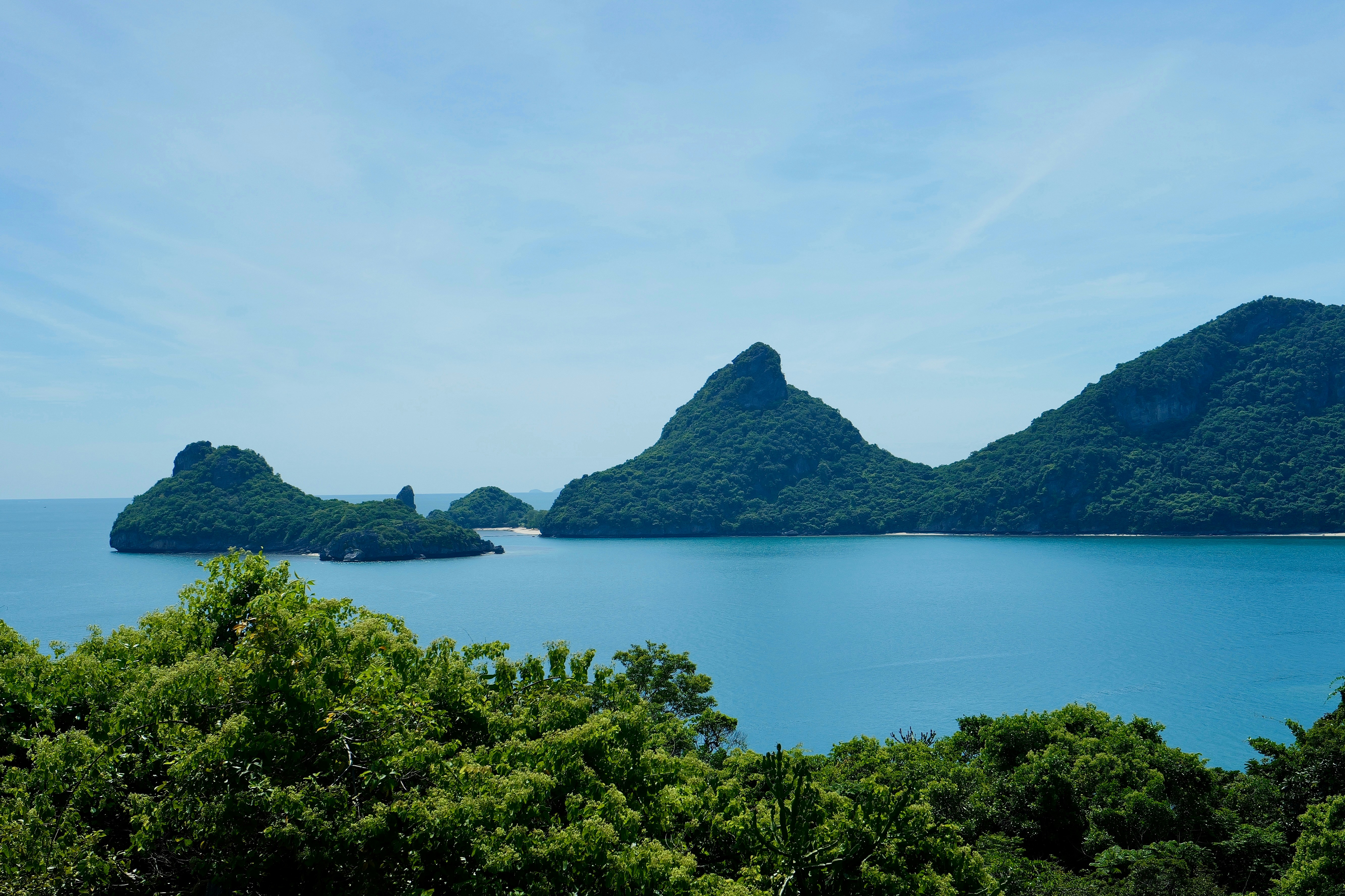Tropical islands emerge from a calm ocean.