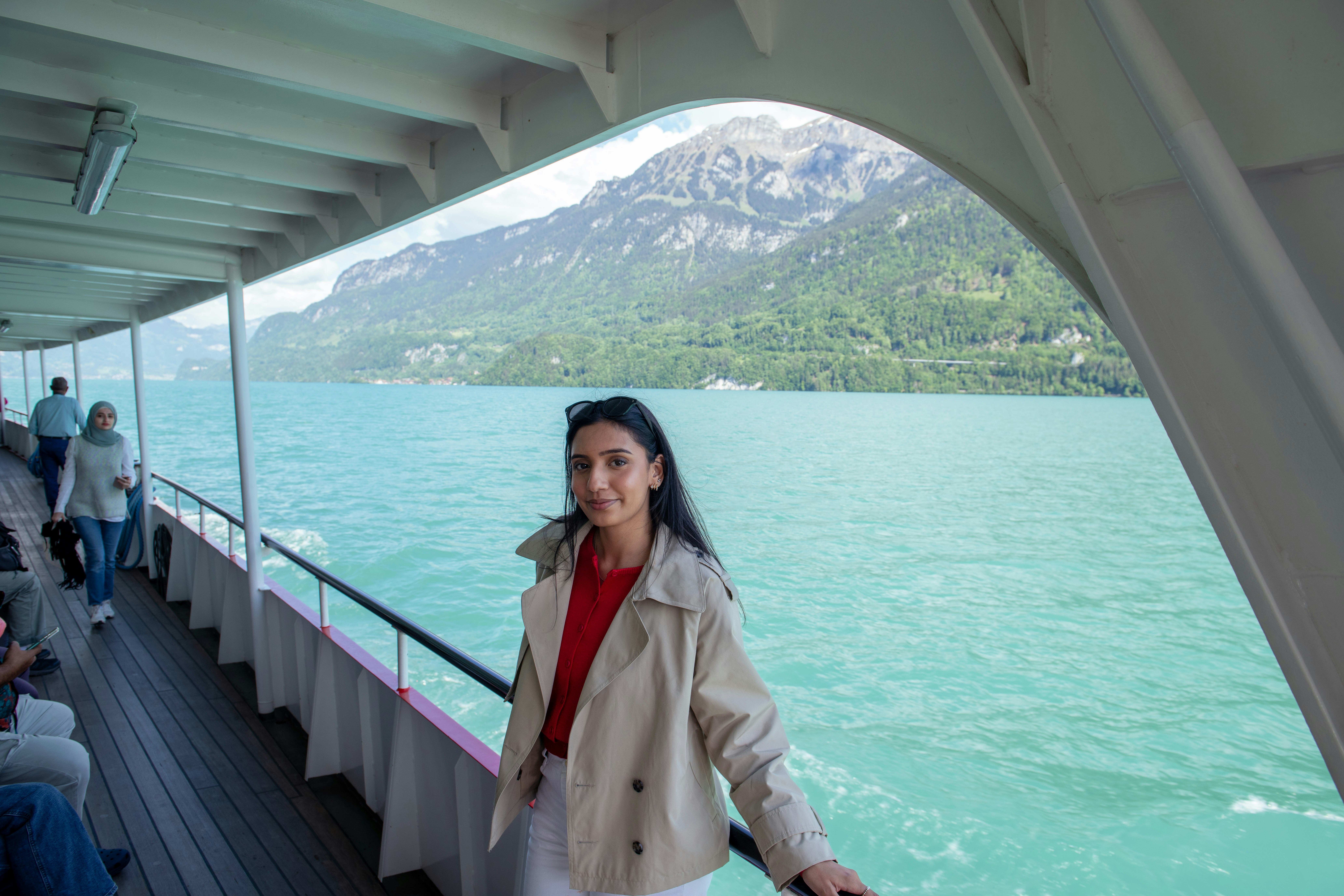 Woman smiles on a boat ride with scenic views.