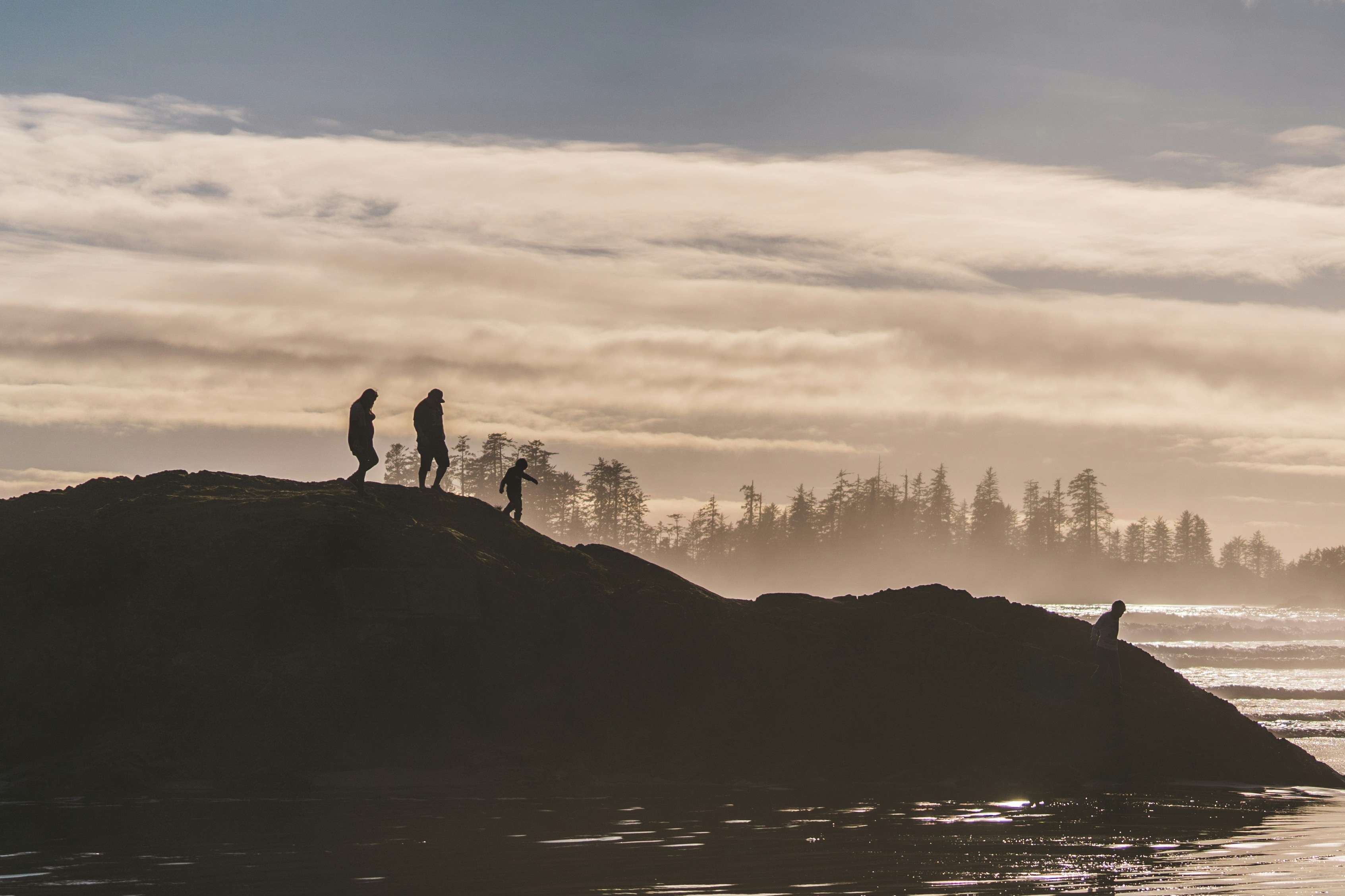 La gente camina sobre una colina con un telón de fondo sereno.