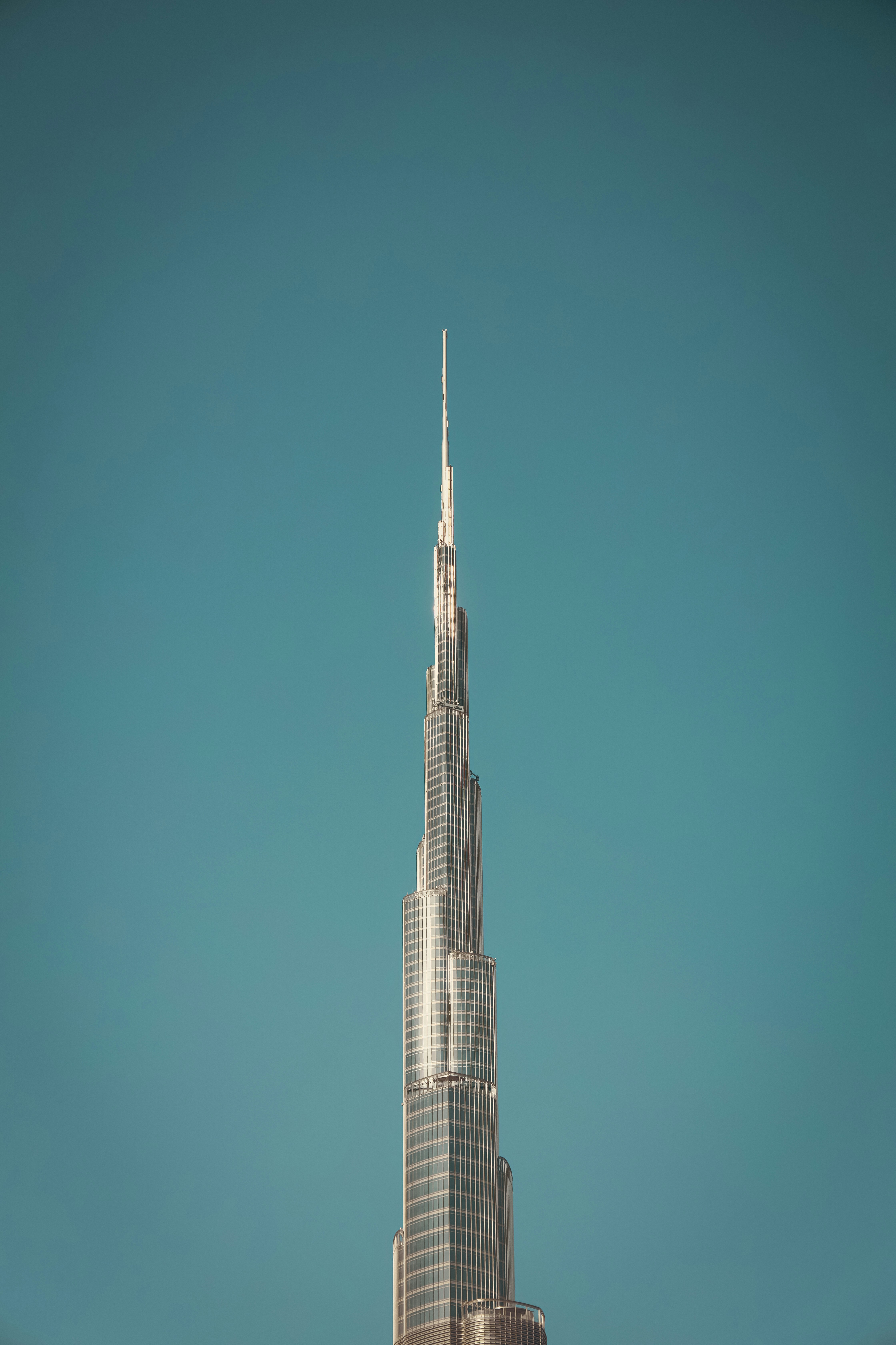 The burj khalifa stands tall against the blue sky.