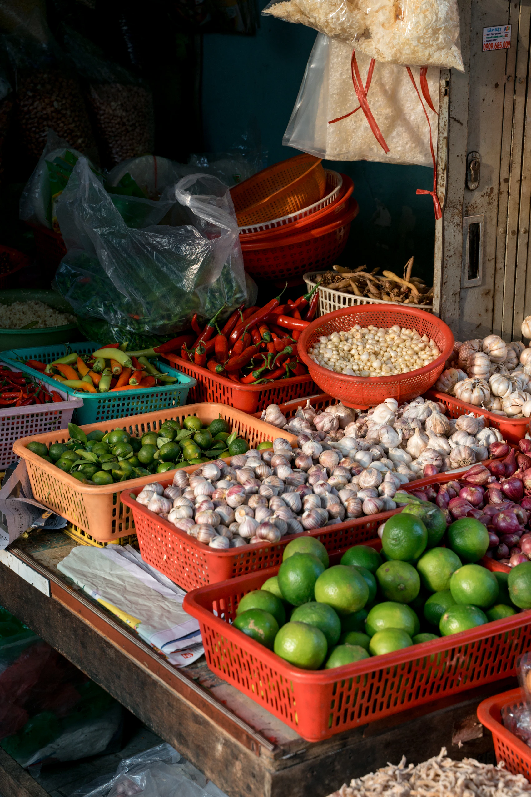 Limes, chillies, garlic and herbs arranged in baskets at a Saigon market