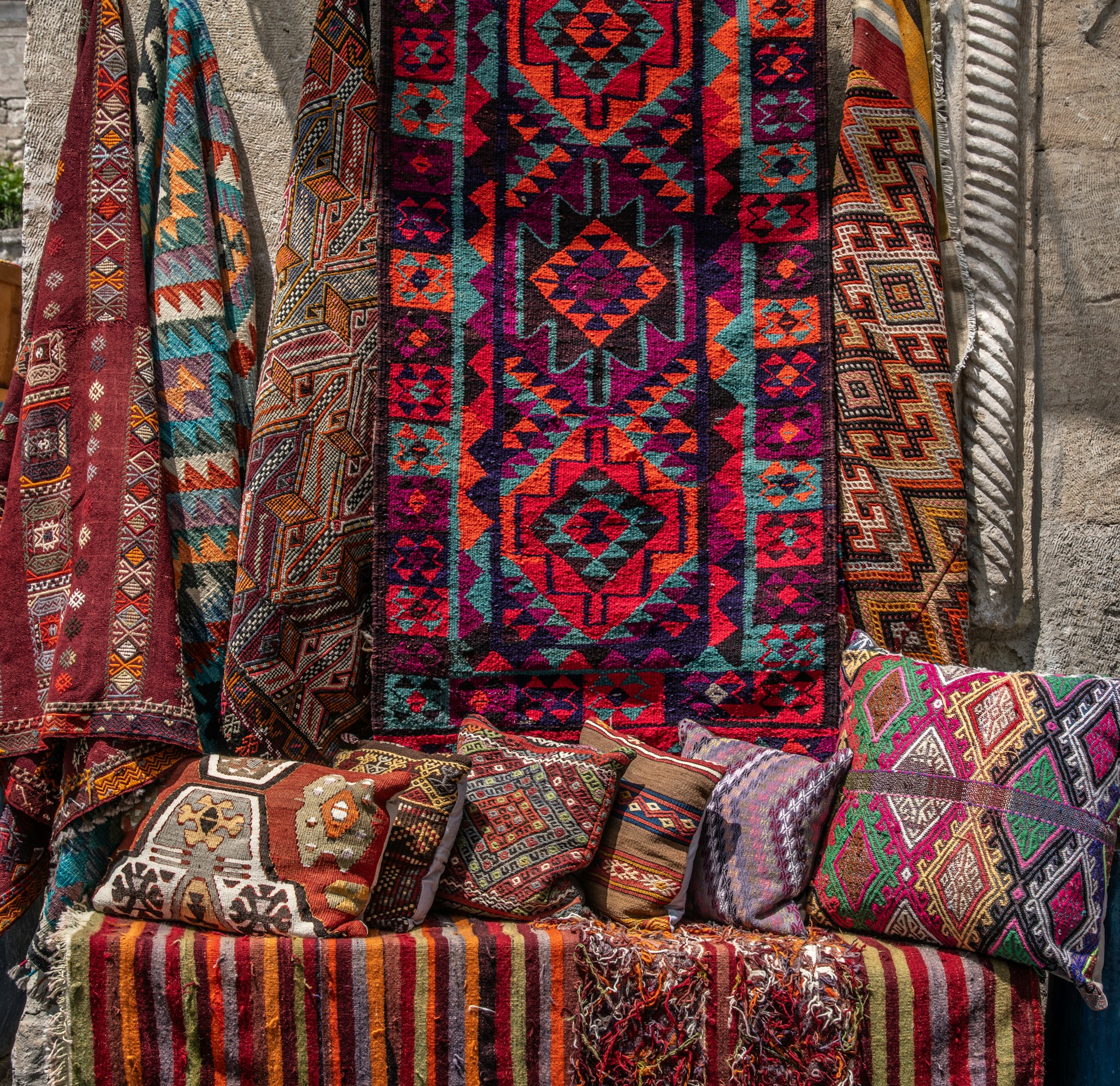 Beautiful, colorful rugs and pillows for sale.