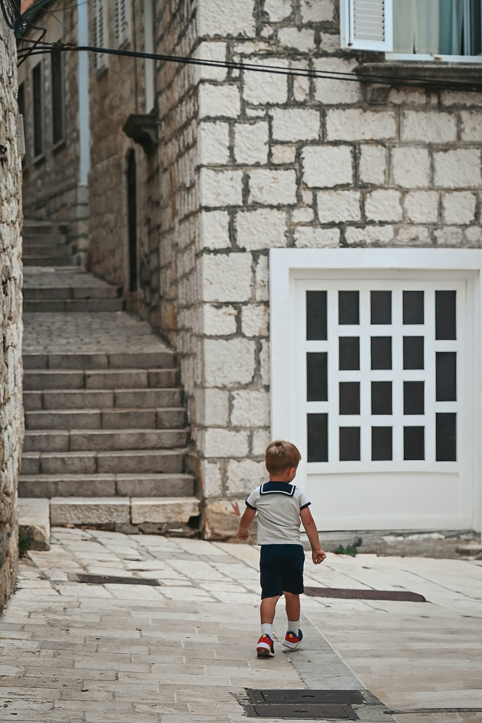 A child walks down a stone street.