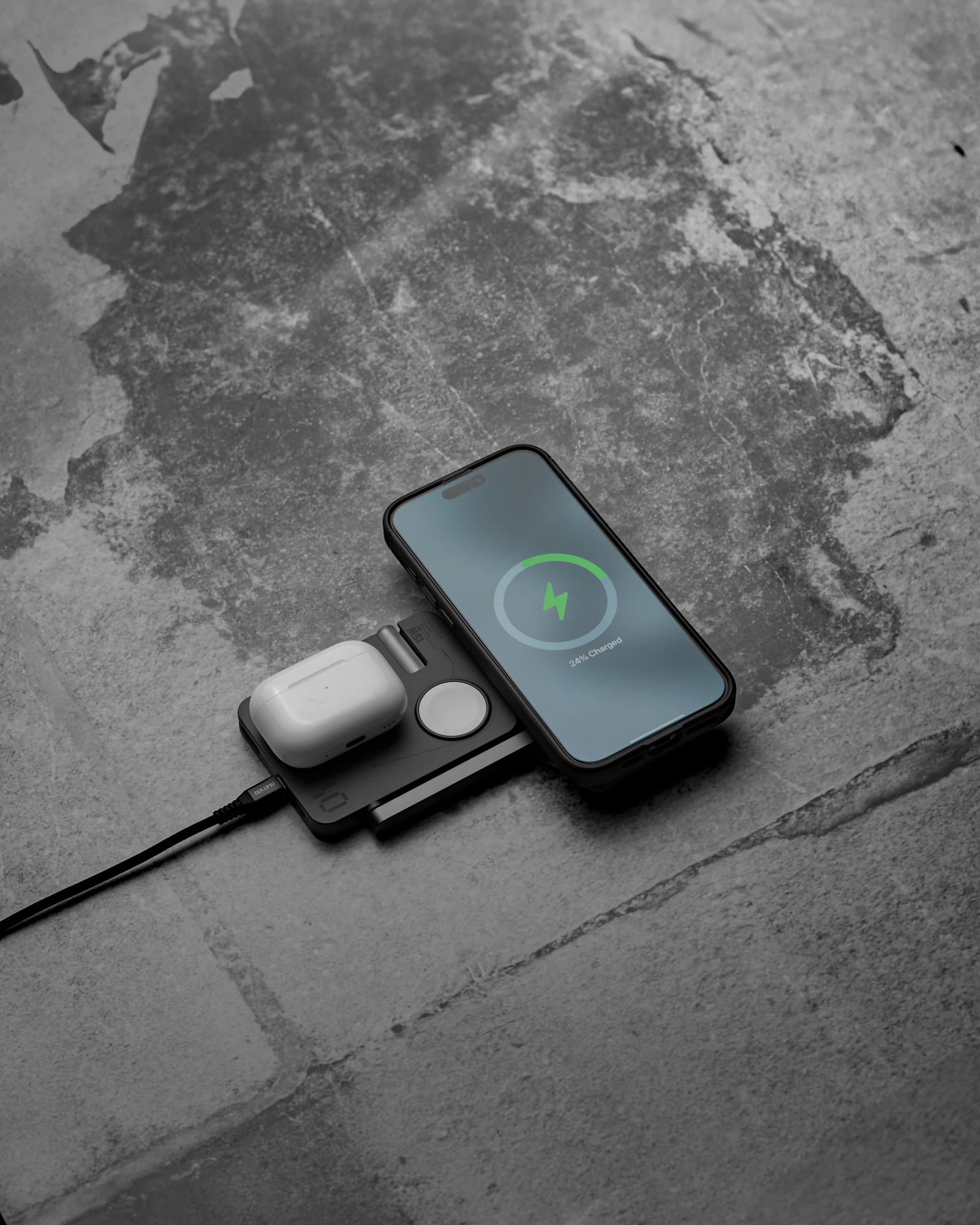 Phone, smartwatch, and wireless earbuds charging together on a compact charging pad