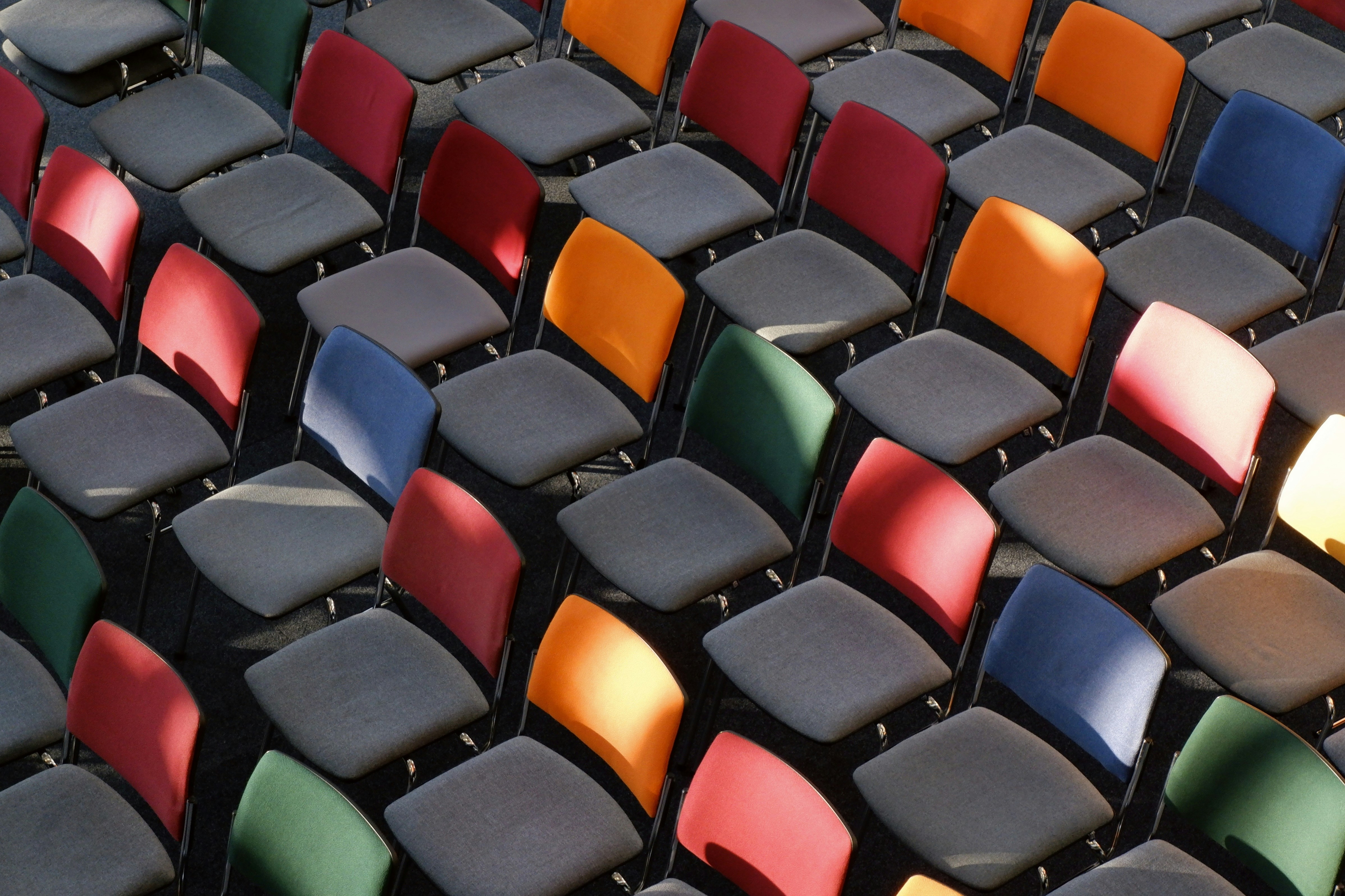 Colorful chairs are arranged in rows.
