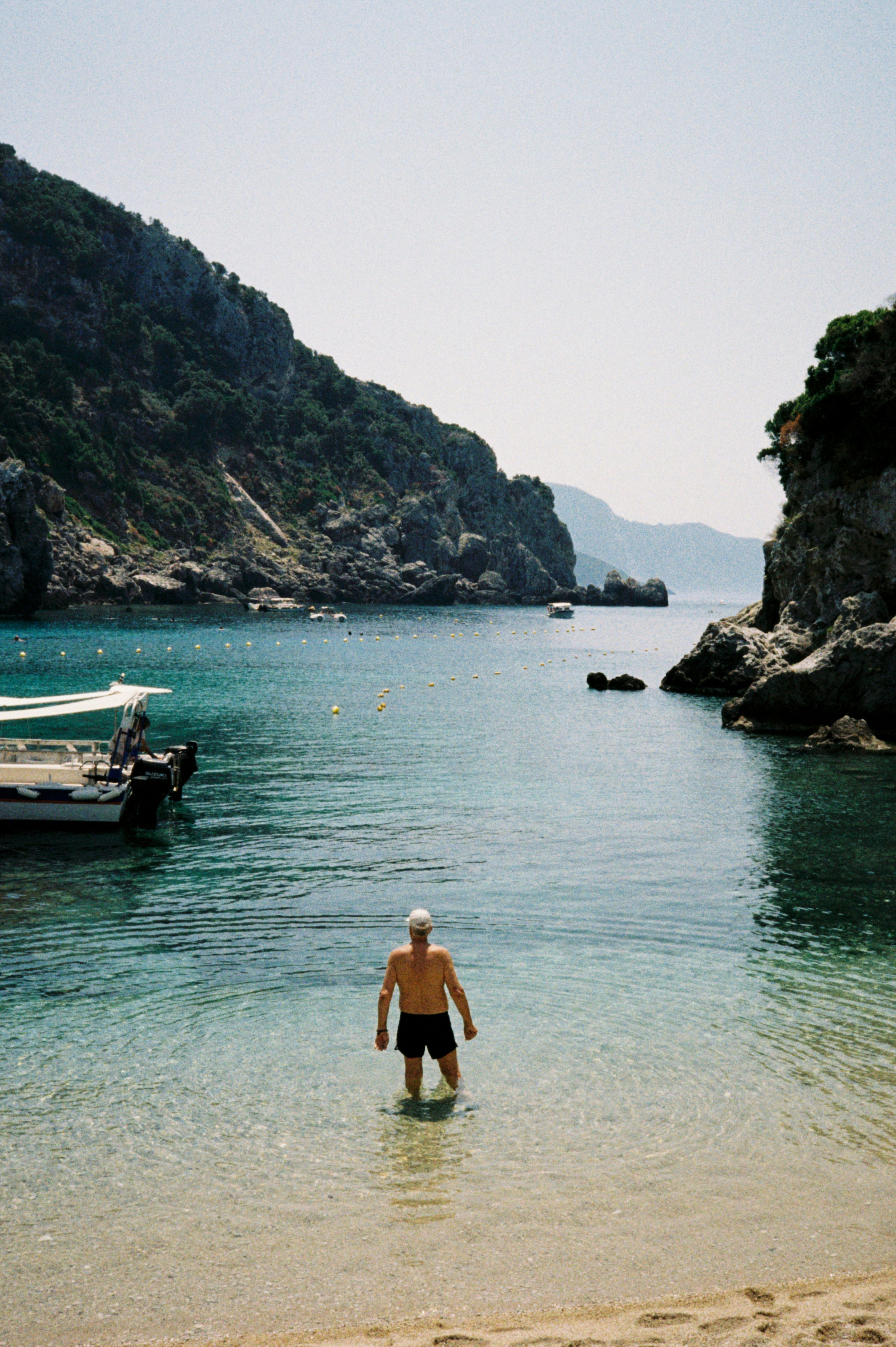 Man wading into clear, blue water.