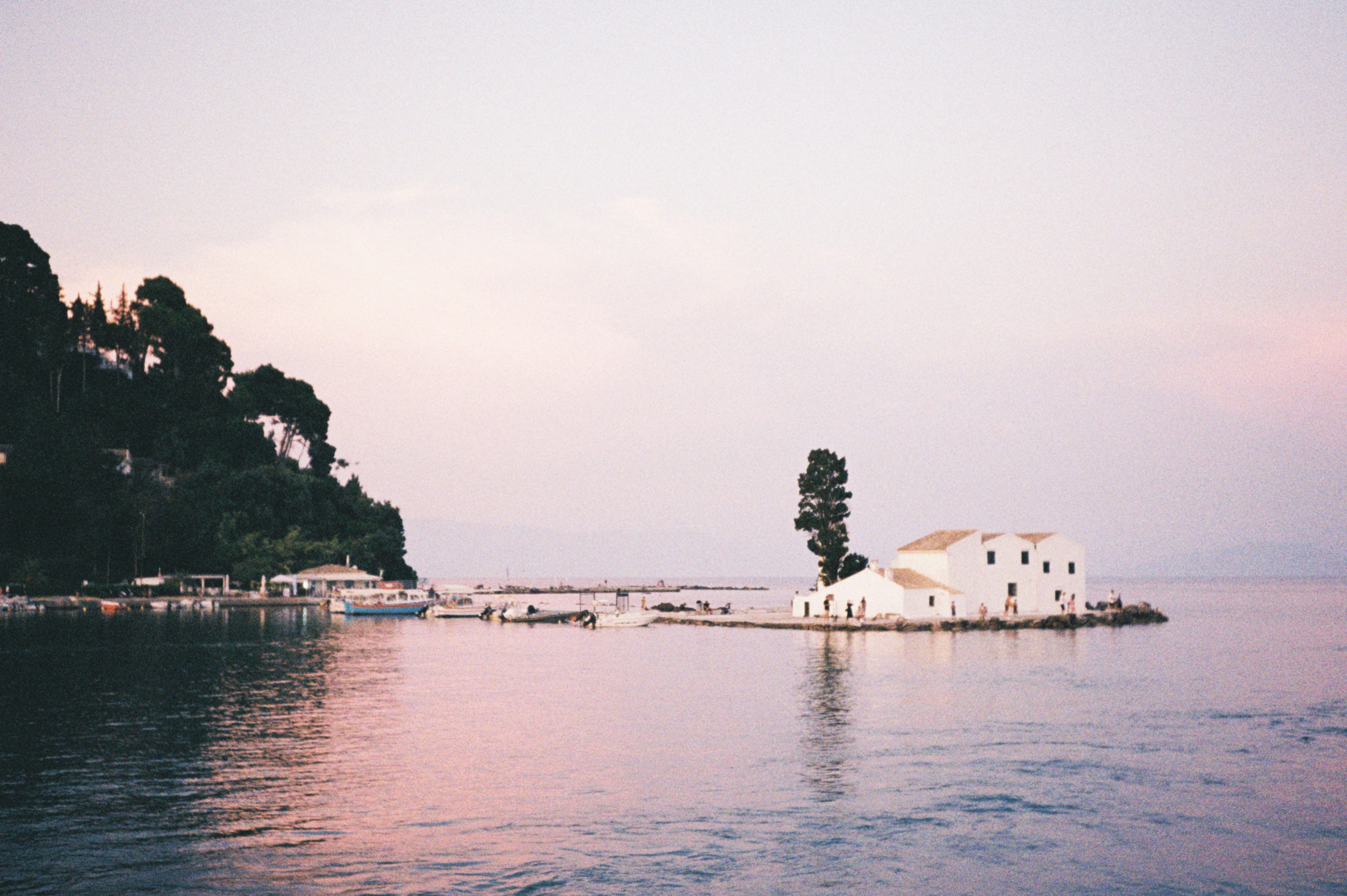 A white church stands on a serene island.