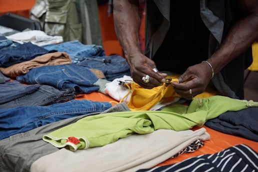 A person folds clothes on a table.