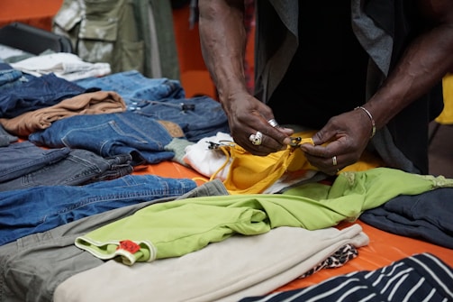 A person folds clothes on a table.