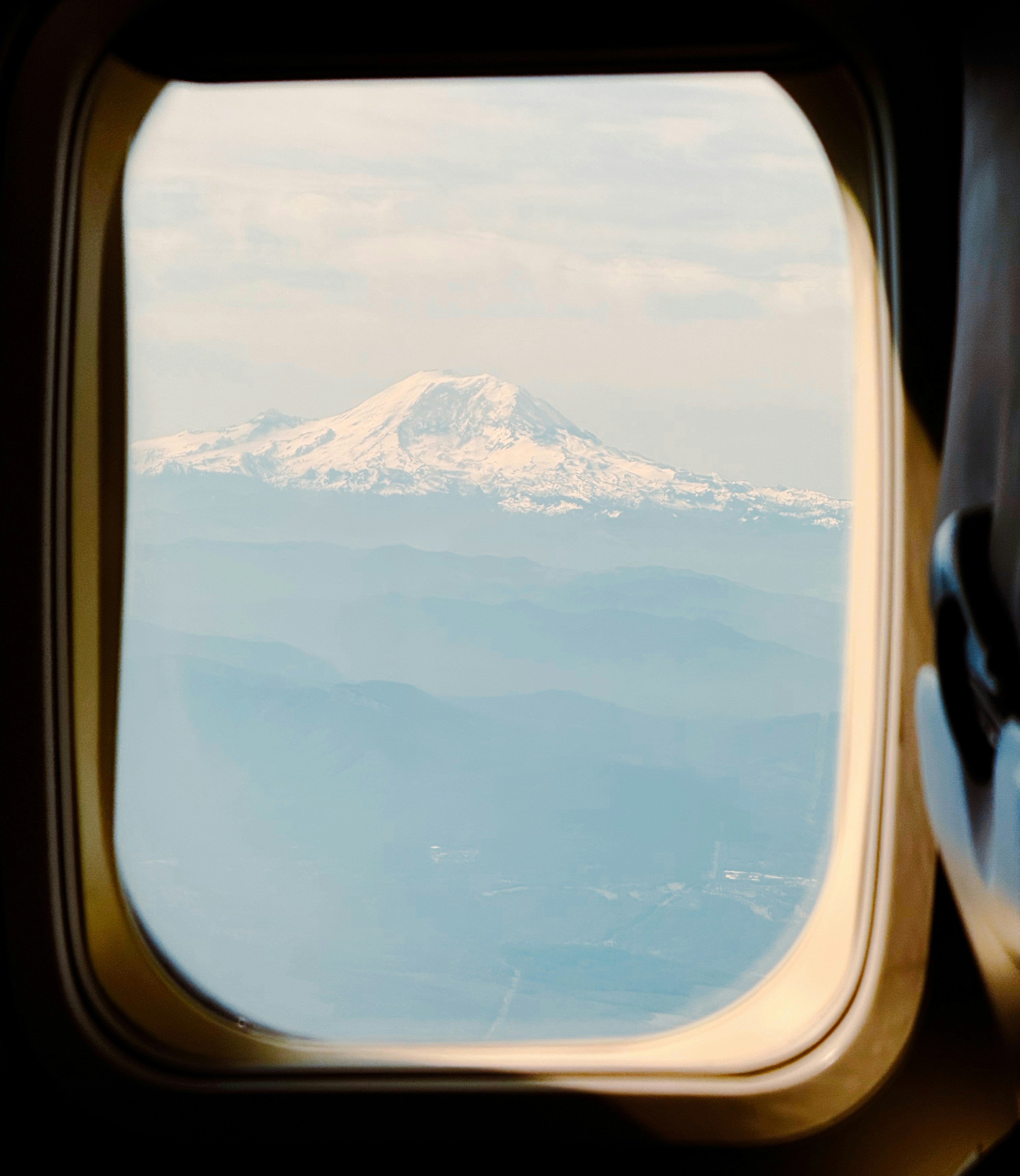 Pic de montagne enneigé vu à travers une fenêtre.