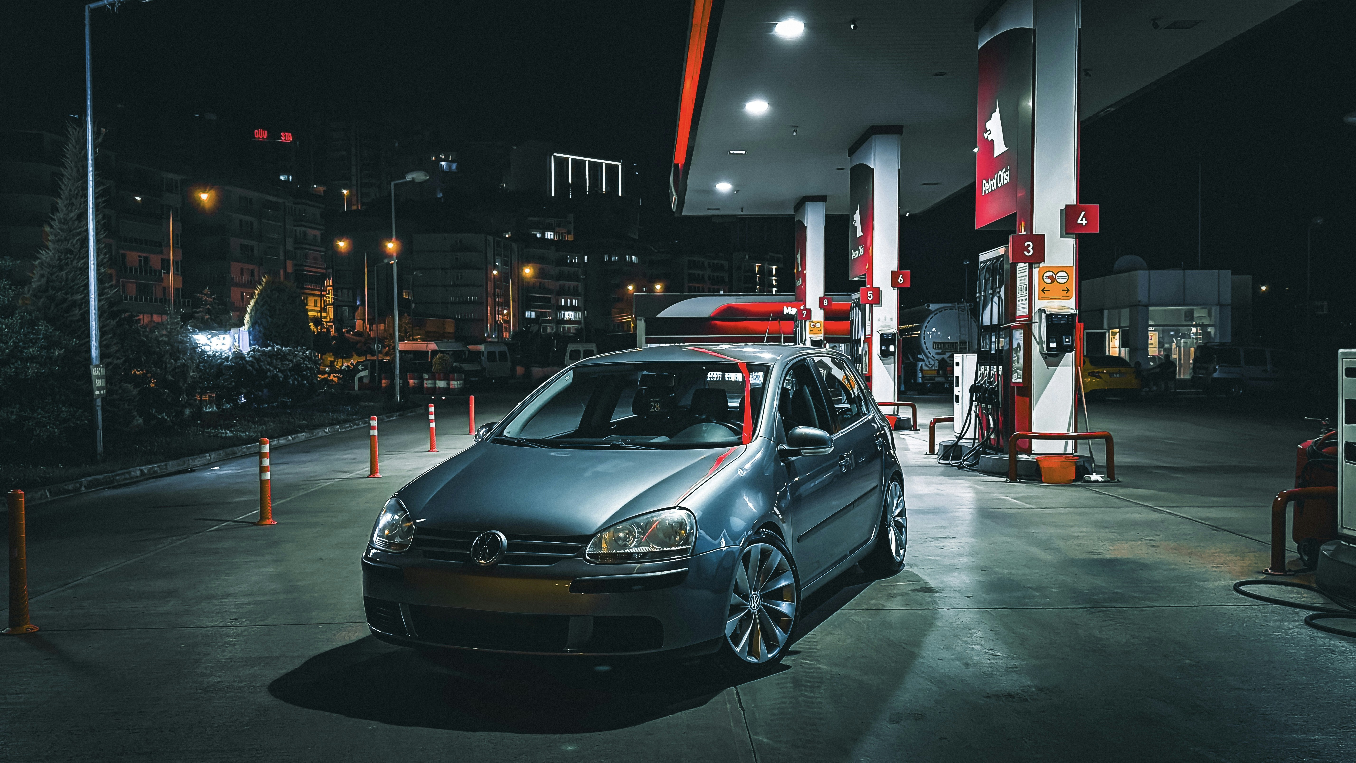 BMW electric car plugged into a public charging station at night in the city