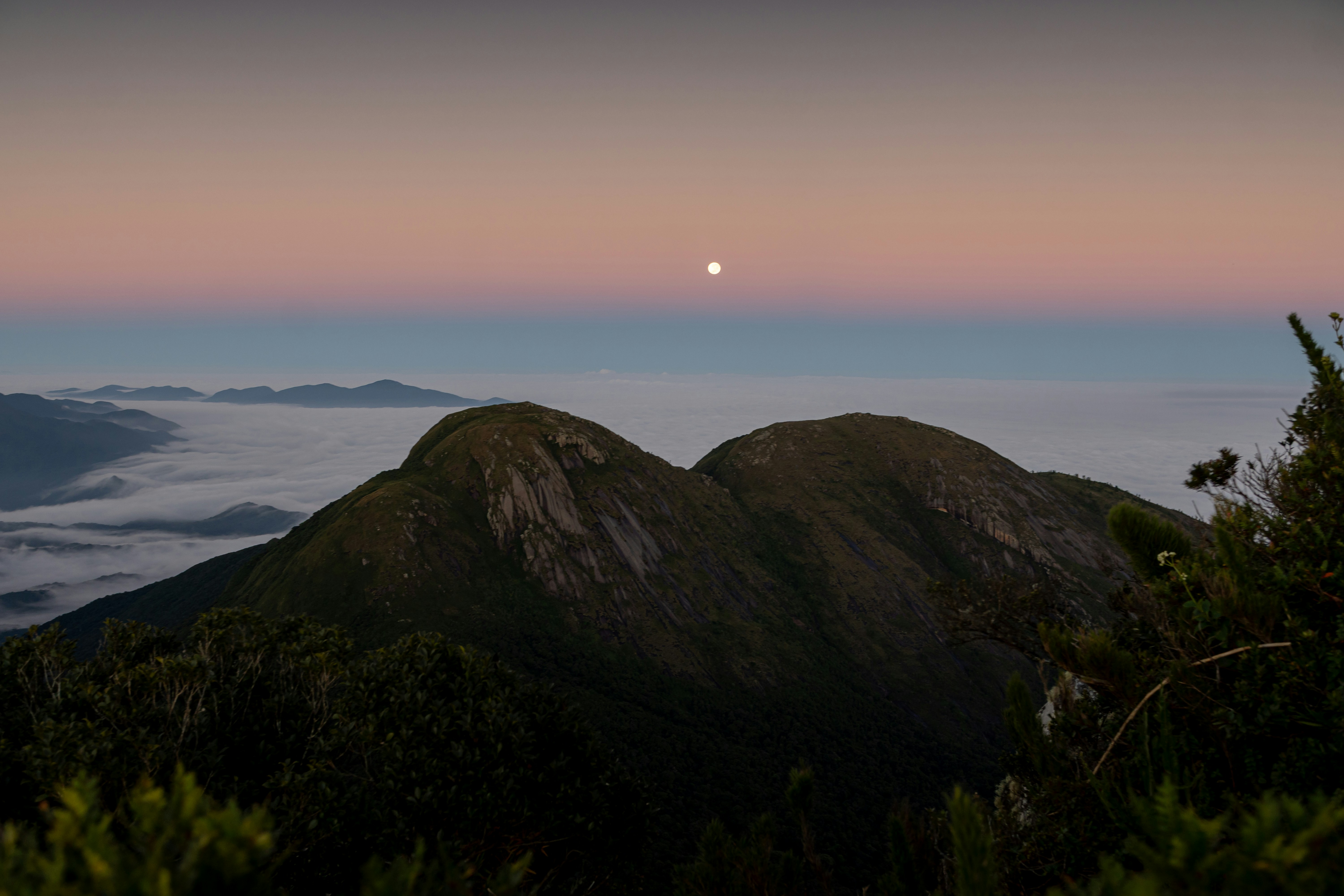 The moon shines over the misty mountains.