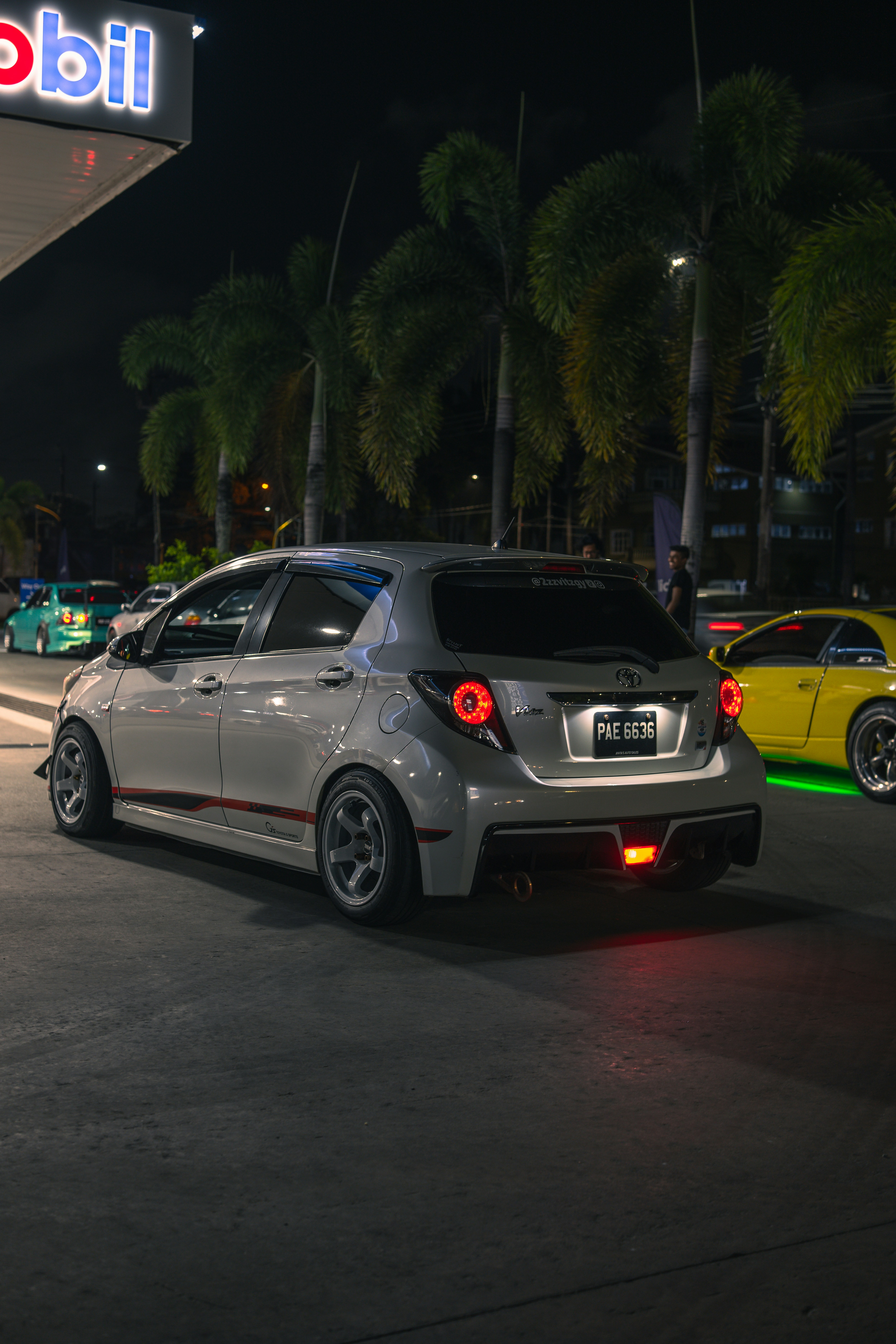 A modified white car at night.