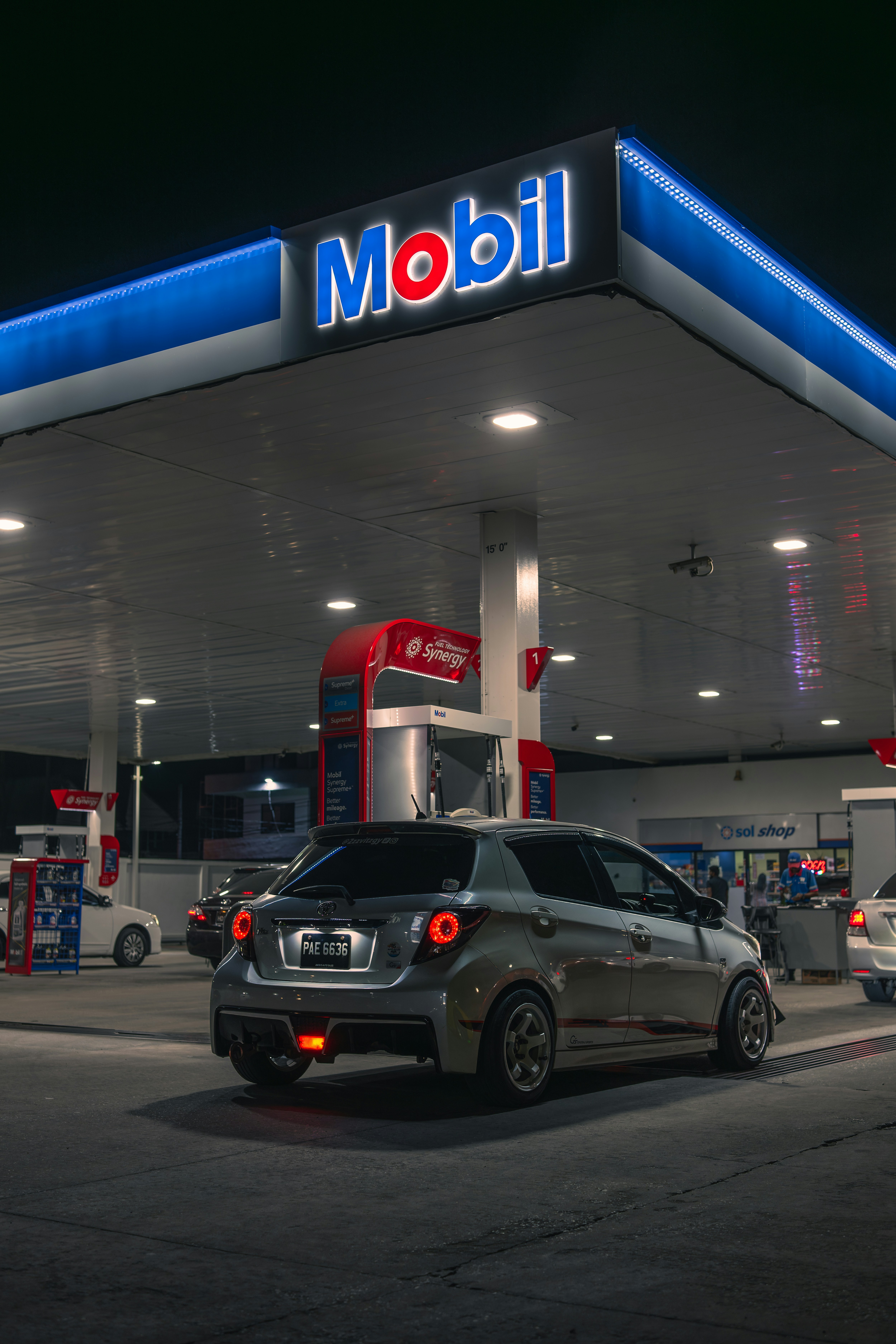 Sebuah mobil berada di pompa bensin mobil pada malam hari.
