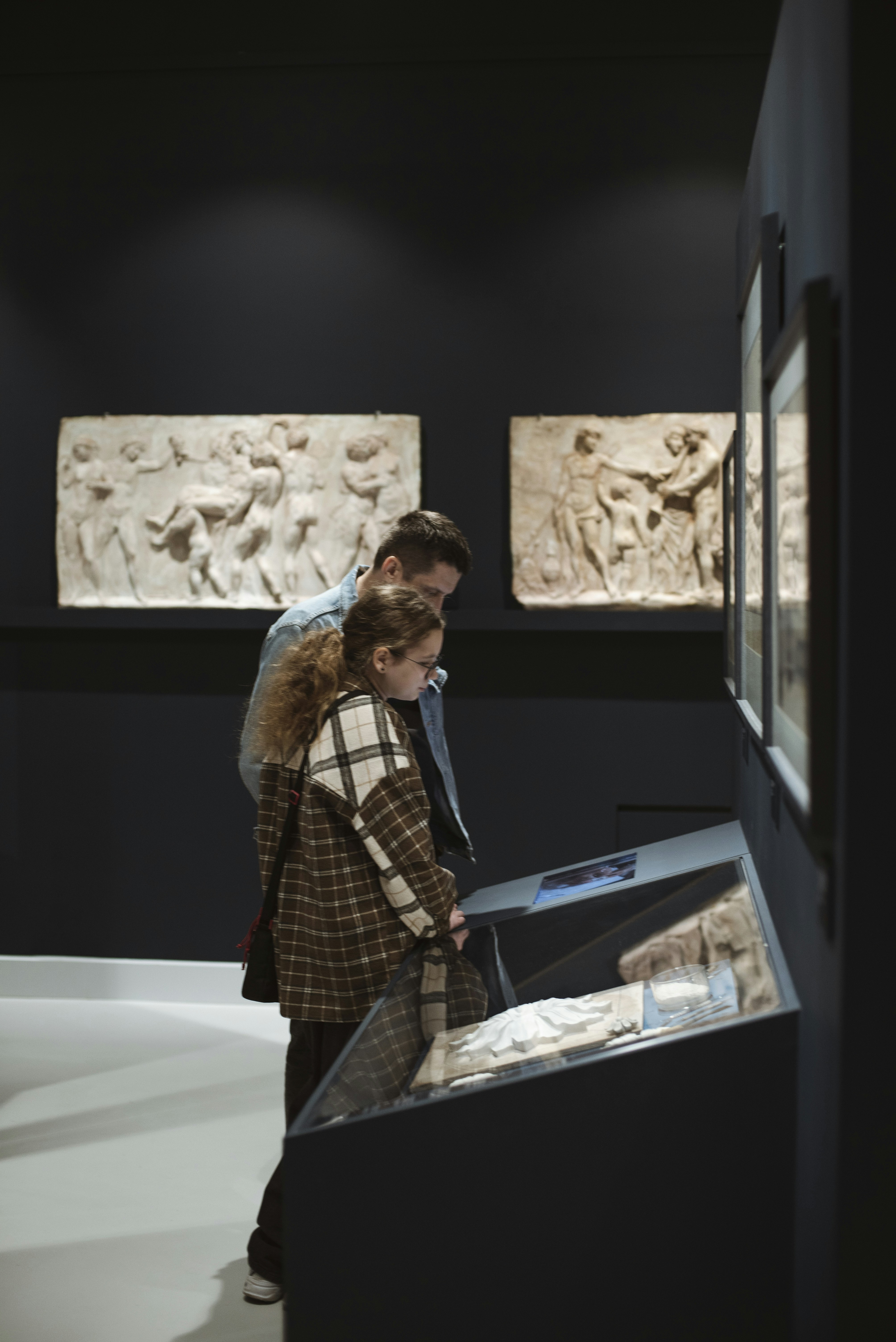 People examine art displays in a museum.
