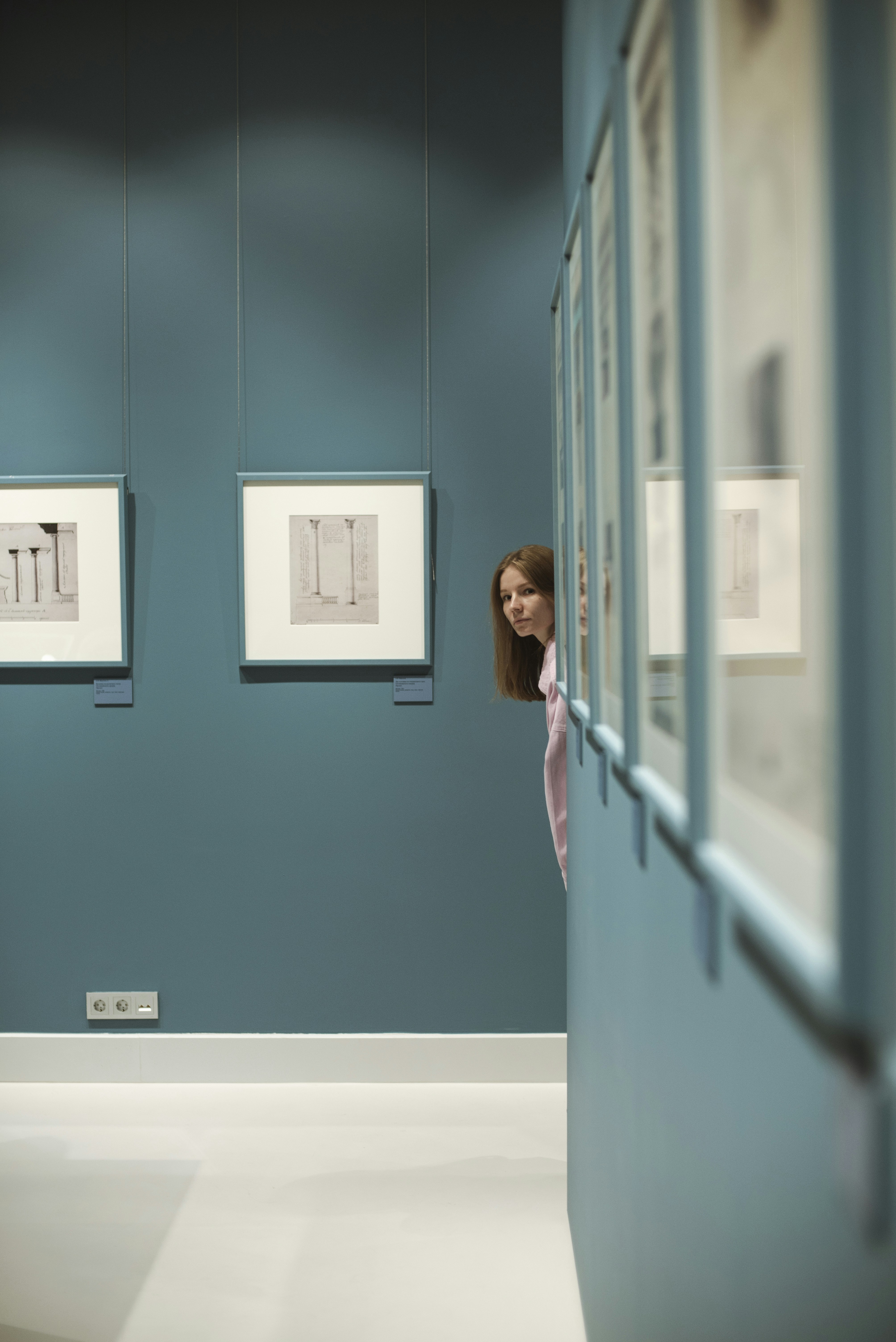 Woman peeks at art in a gallery.