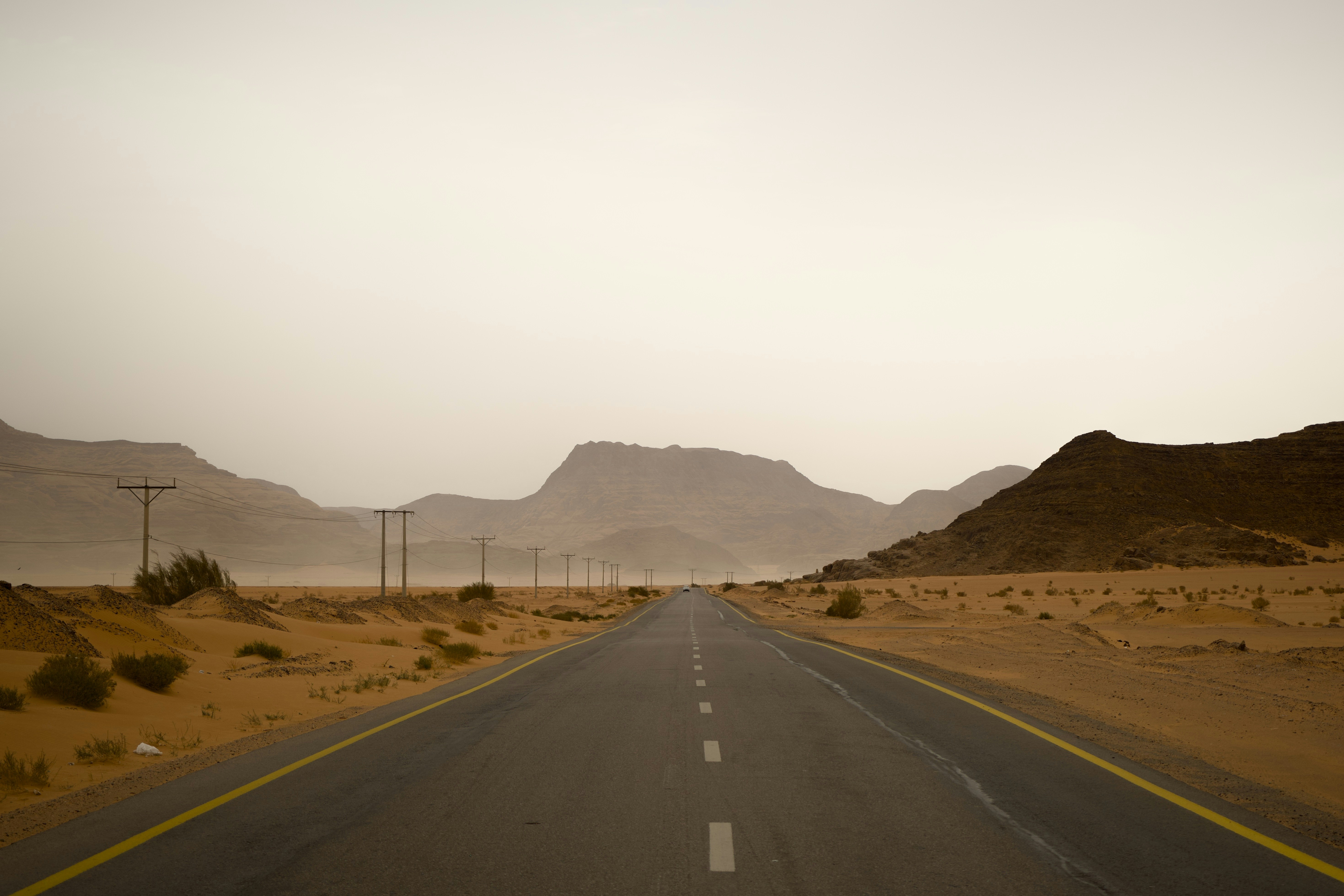Road leads into a desert landscape with mountains.