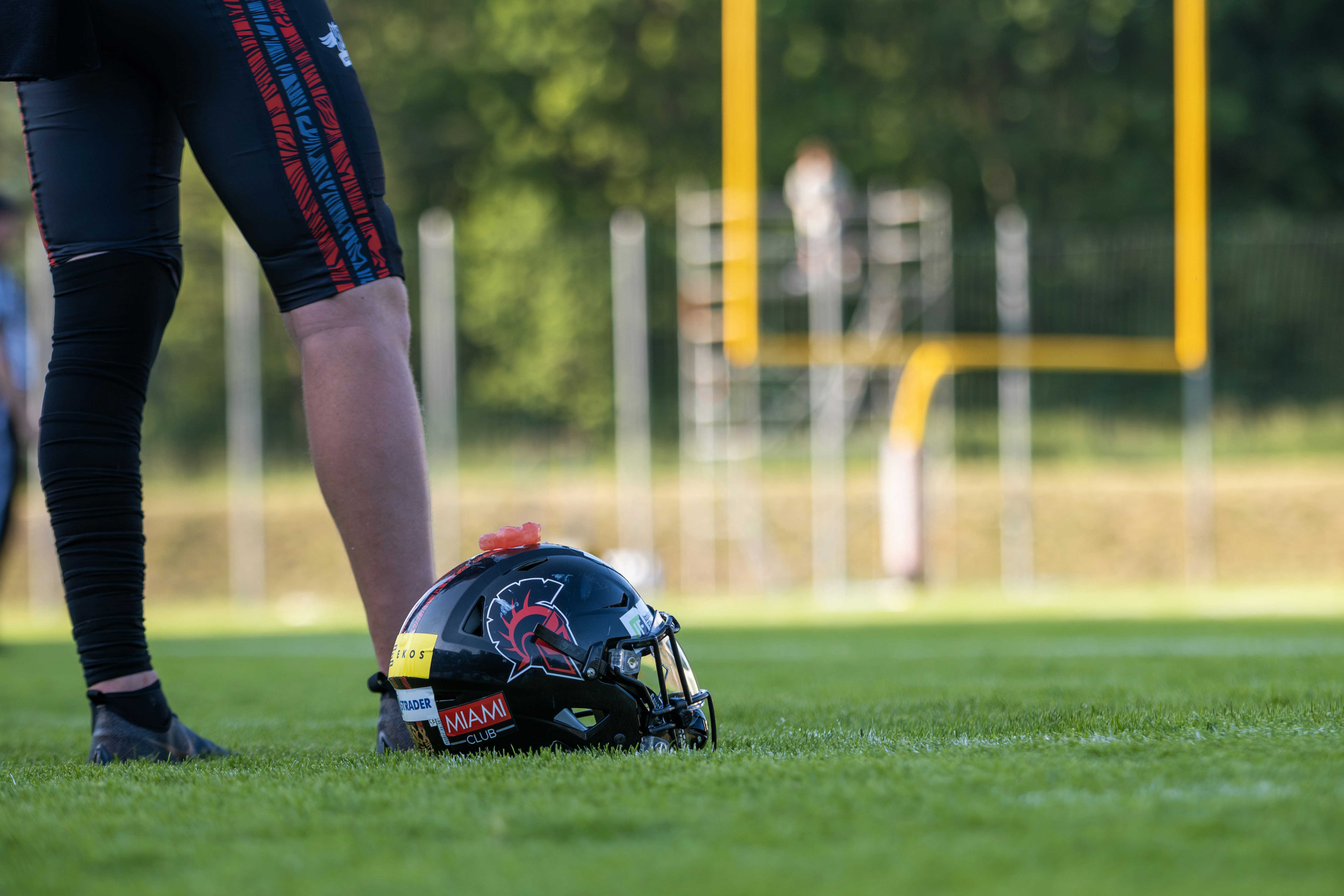 Jugador de fútbol de pie con casco en el campo.