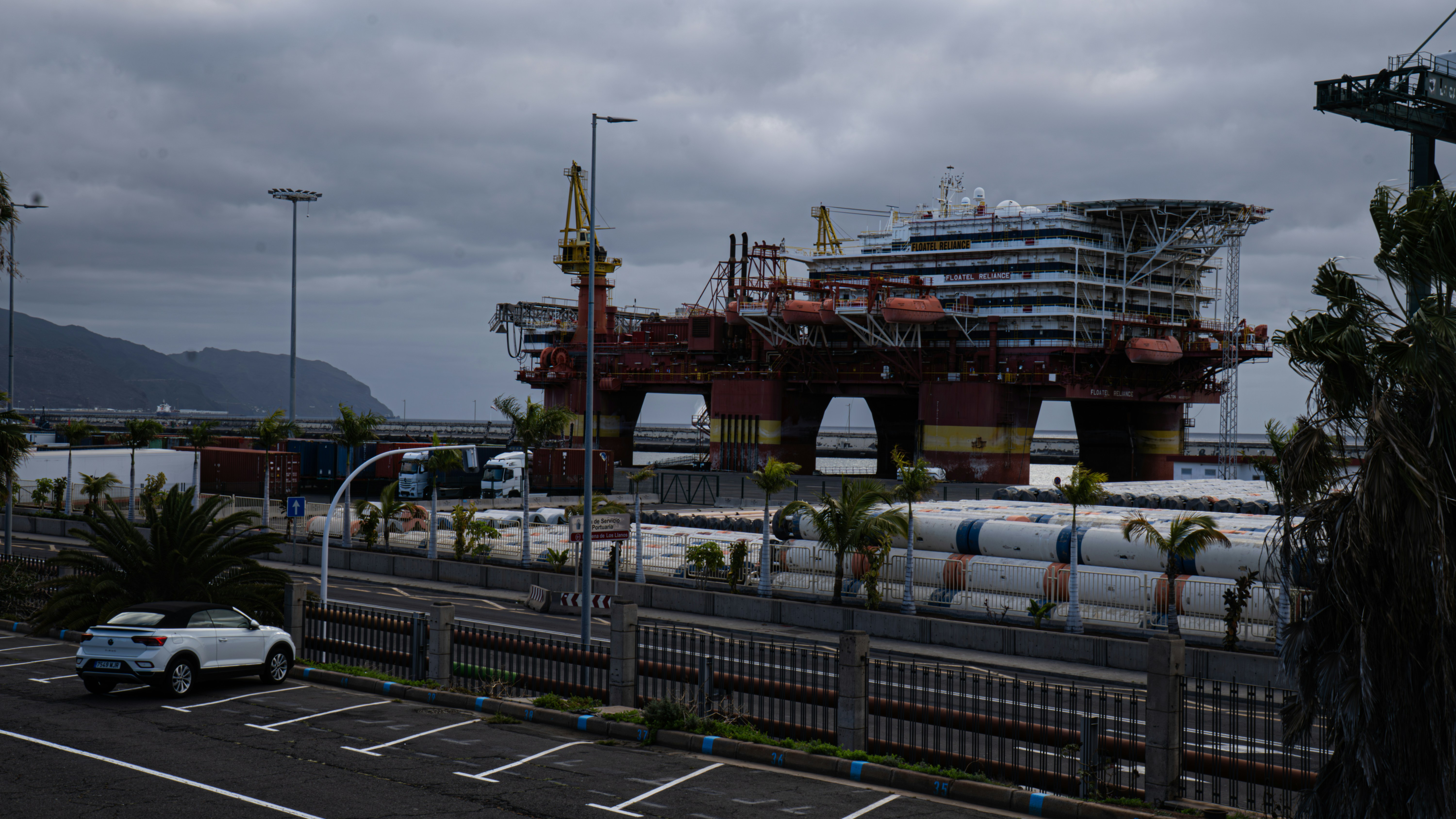 Oil rig sits docked at a harbor.