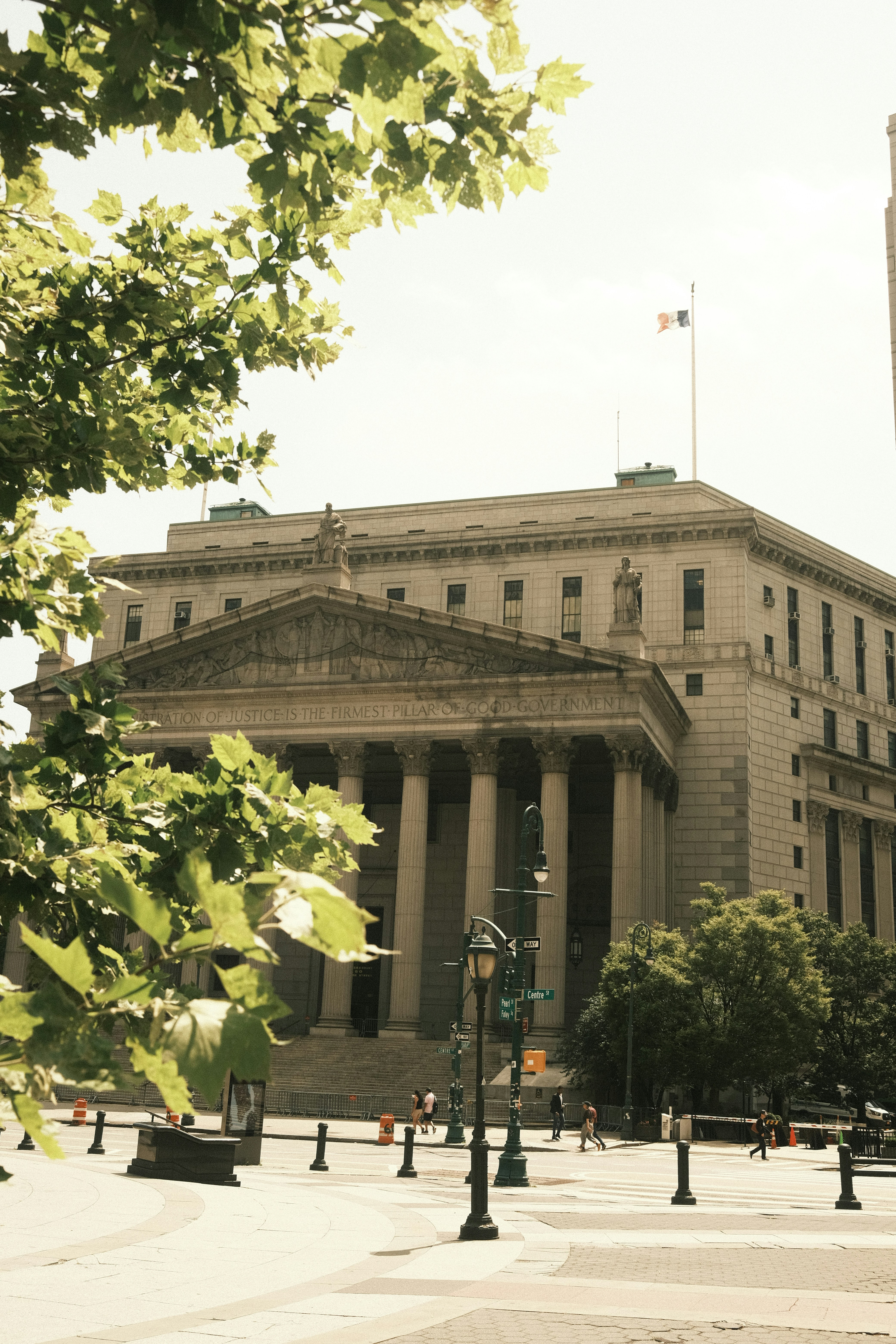 A courthouse stands tall with columns and trees.