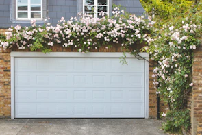 Garage door is covered with beautiful climbing roses.