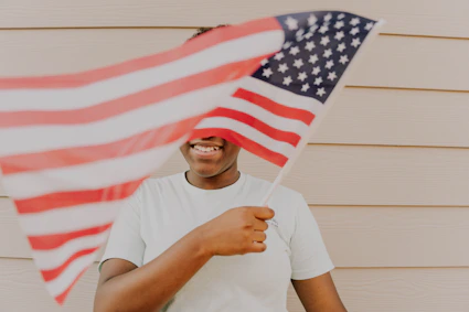 Person holds an american flag, smiling and happy