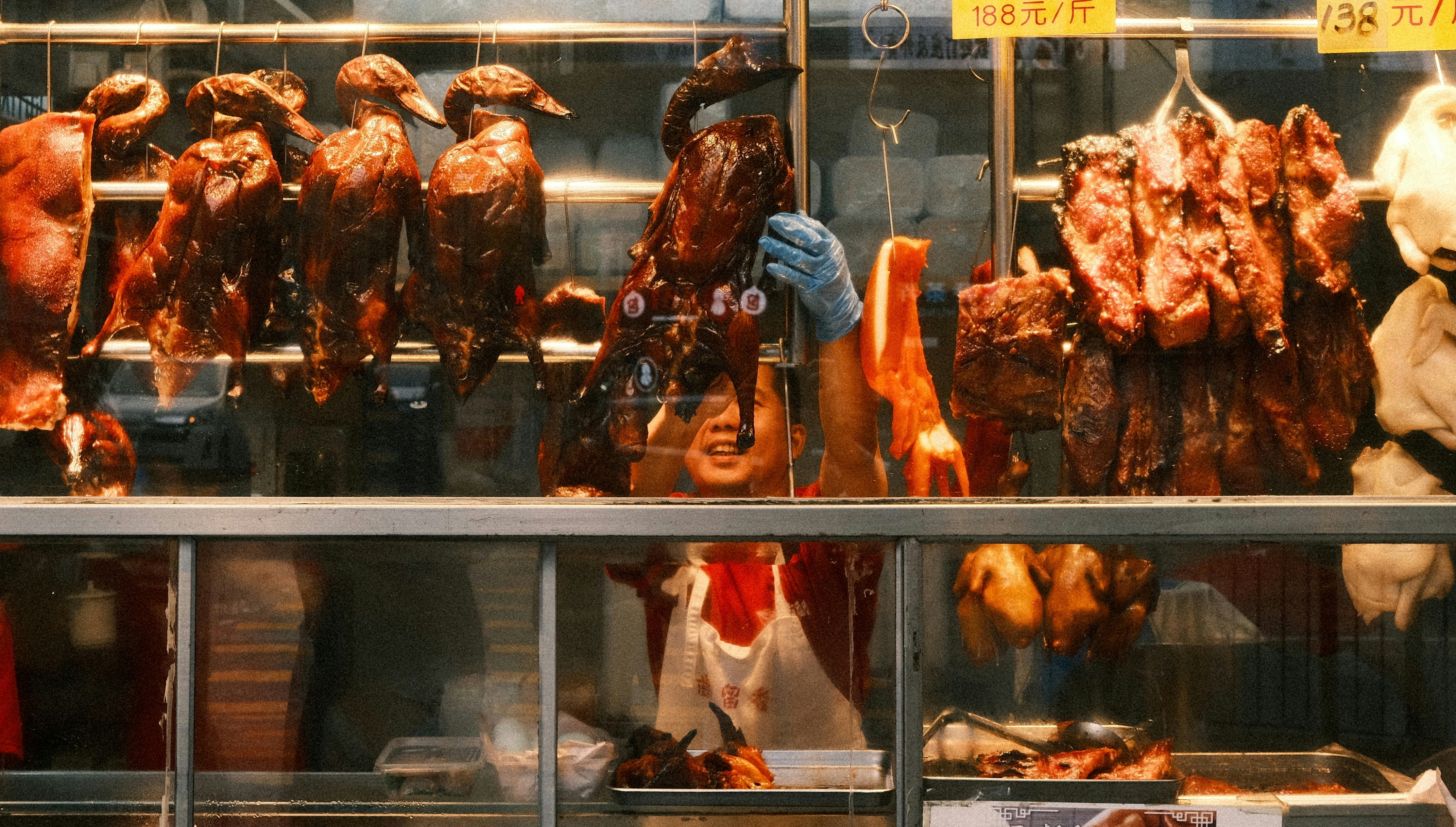 Roasted ducks are hanging at a meat shop.