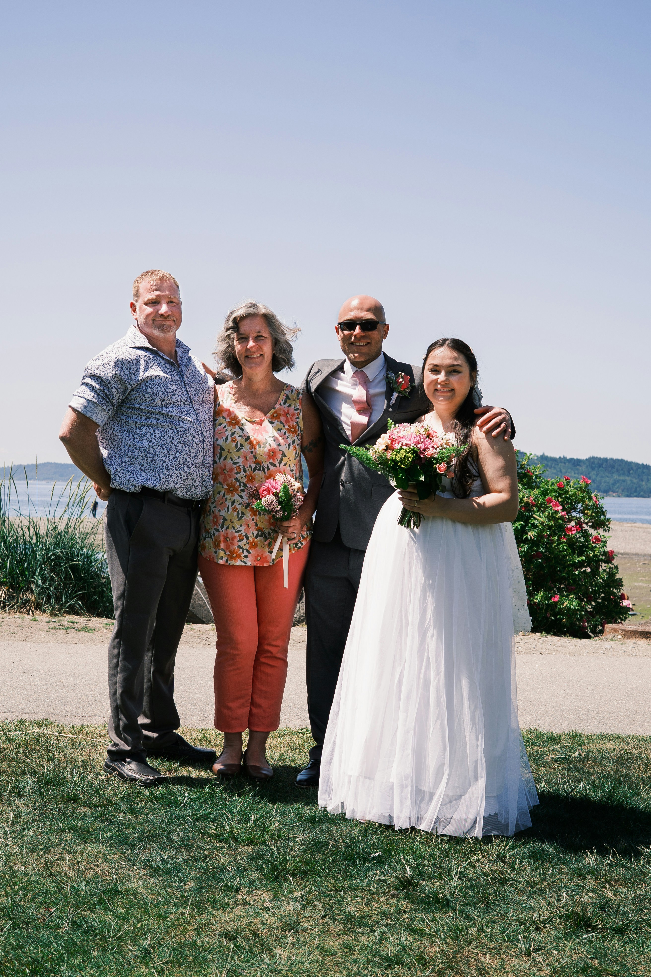 Una fiesta de bodas posa para una foto al aire libre.
