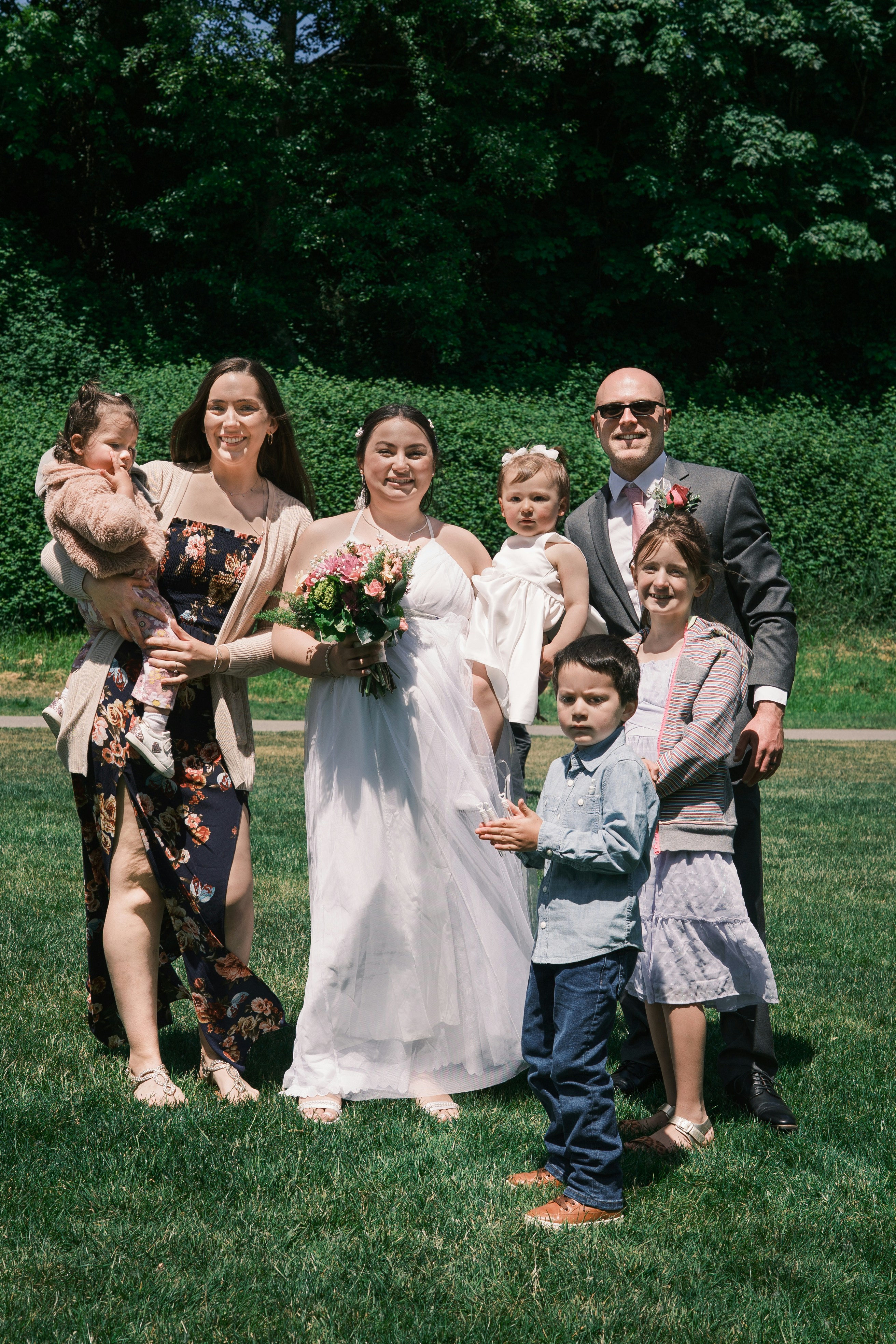 Una novia posa con su familia en un día soleado.