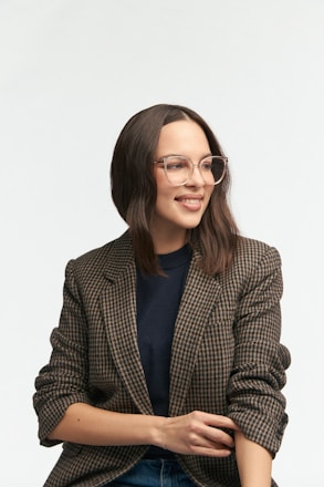 Smiling woman in a blazer and glasses.