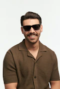 A smiling man is wearing sunglasses.